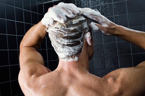 Photo of a man washing his hair with a shampoo | Photo: Getty Images