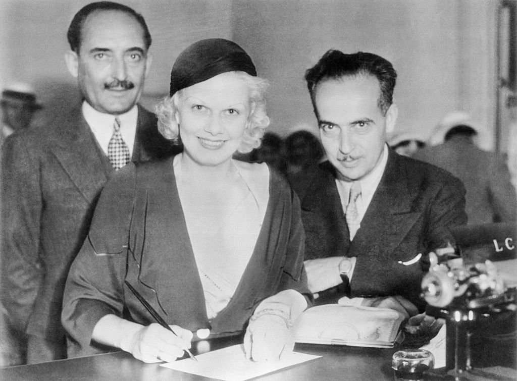 Jean Harlow, platinum blonde star of the movies, with Paul Bern, singing the wedding papers, in Beverly Hills, in July 2, 1932. | Source: Getty Images