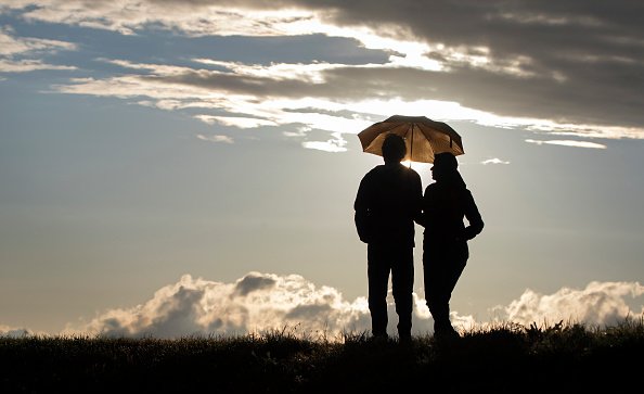 Un couple se promène sous un parapluie. |Photo : Getty Images