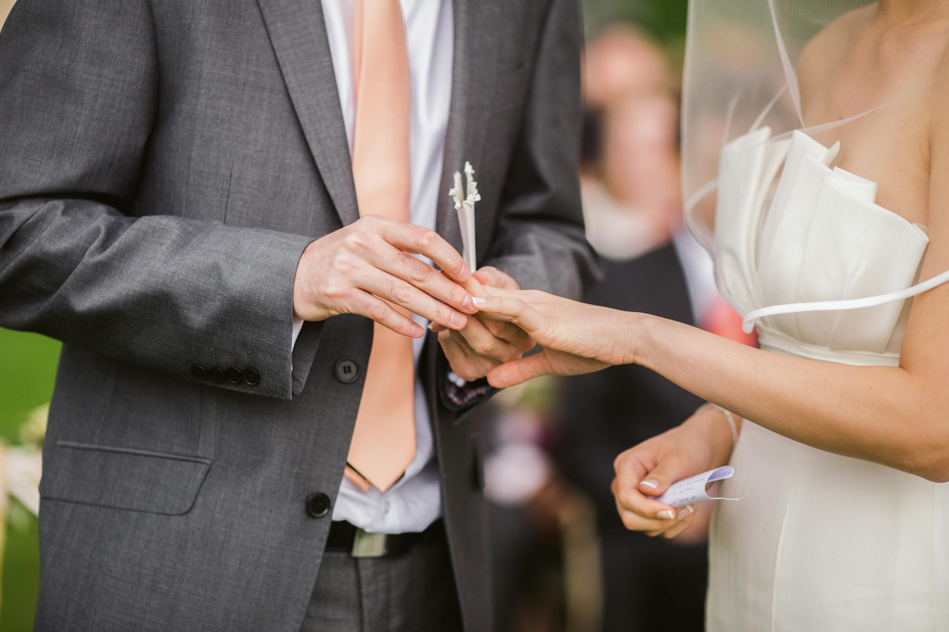 A groom putting a wedding ring on his bride's finger | Source: Pexels