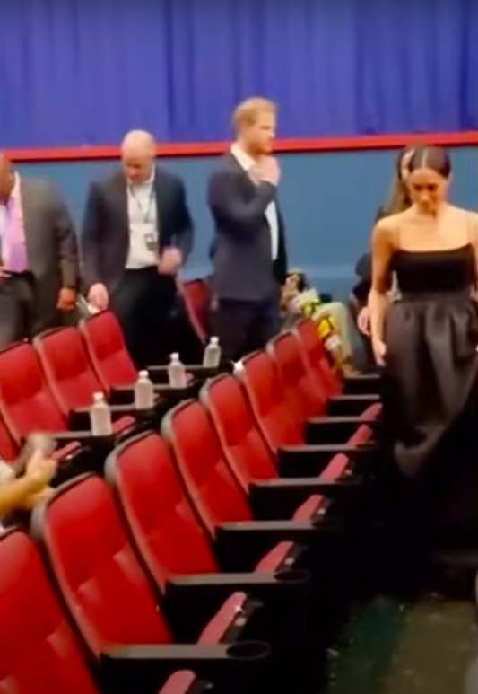 Prince Harry and Meghan Markle walking to their seats posted on January 28, 2024 | Source: YouTube/Page Six