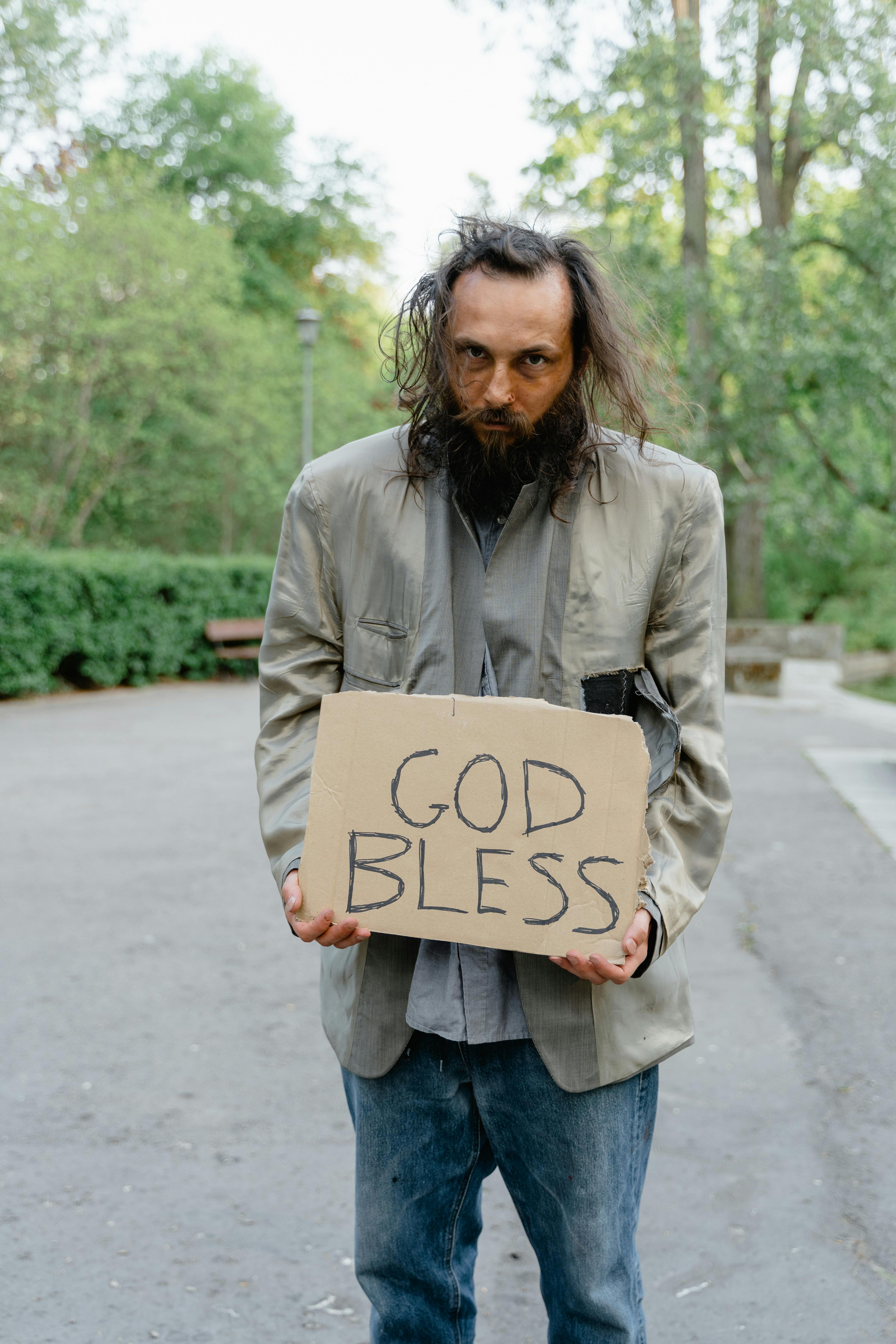A destitute man holding a sign | Source: Pexels