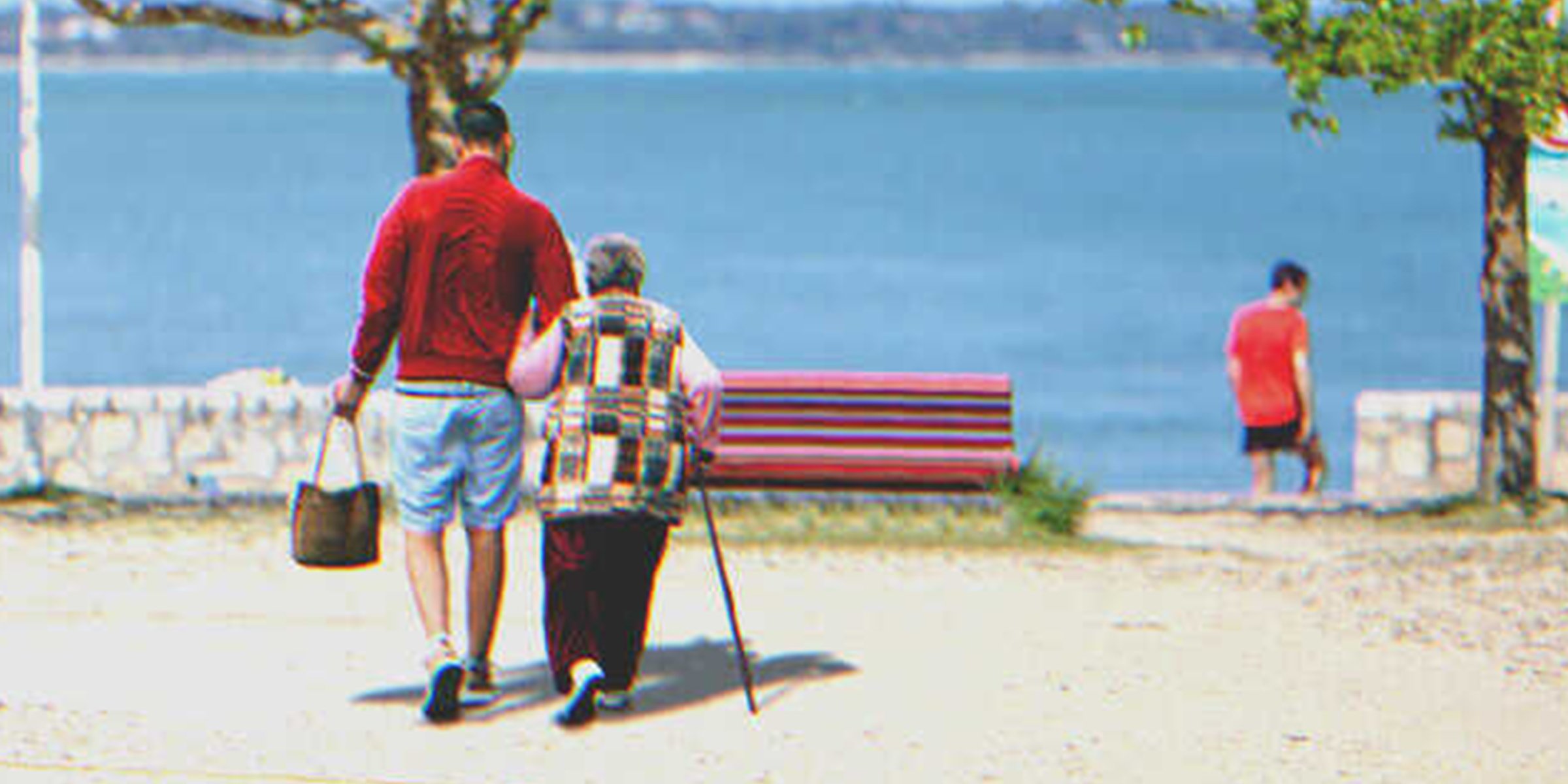 A man and an old lady walking towards the sea | Source: Shutterstock