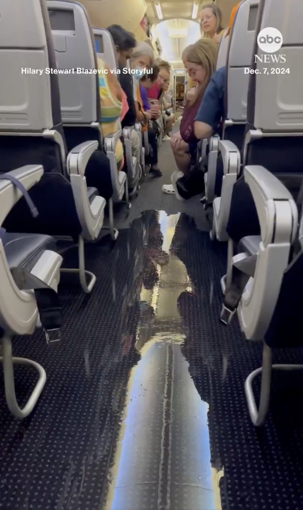 Passengers look on worriedly as water fills the aisle of an American Airlines plane, from a post dated December 15, 2024 | Source: X/ABC