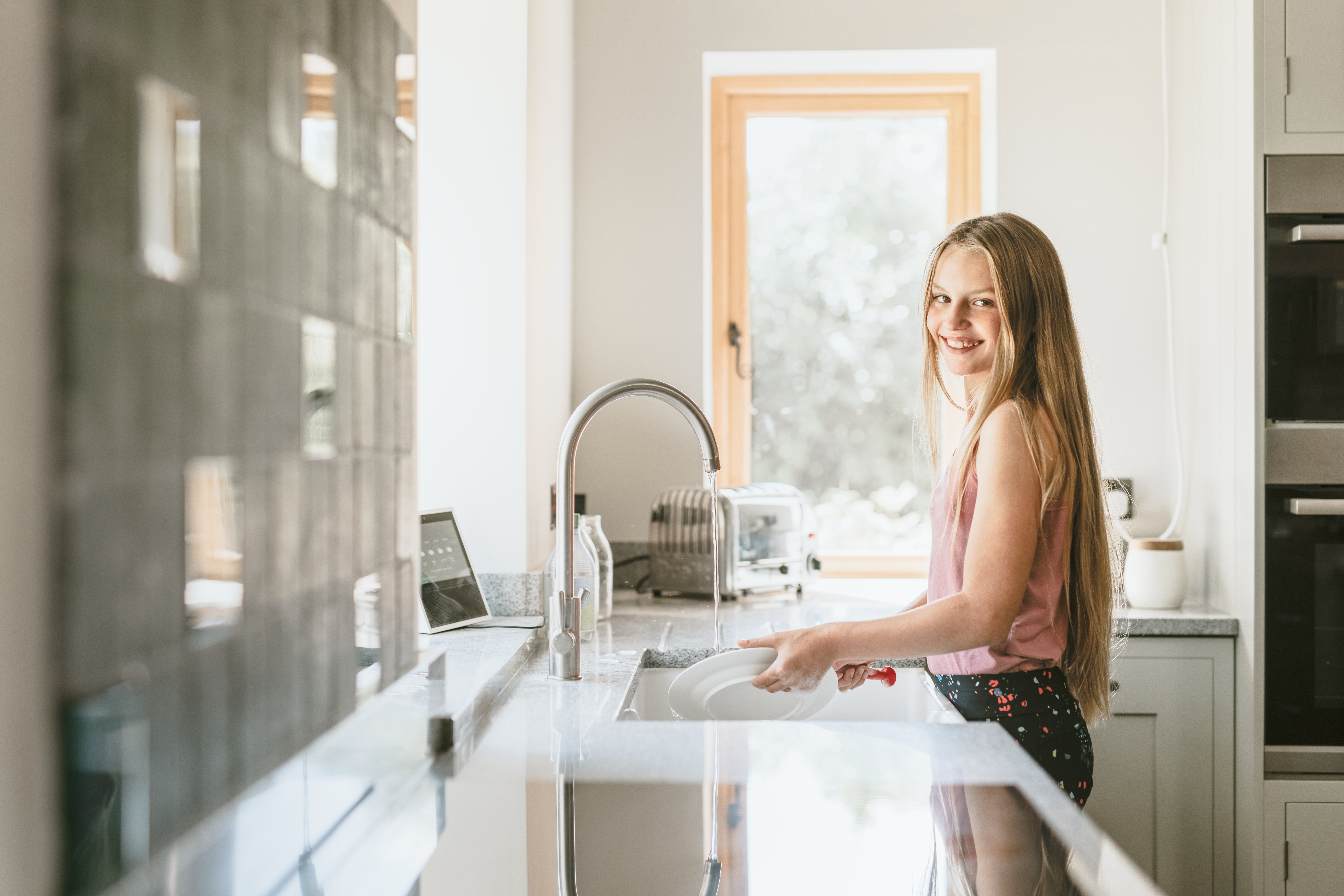 Girl wash the dishes | Shutterstock