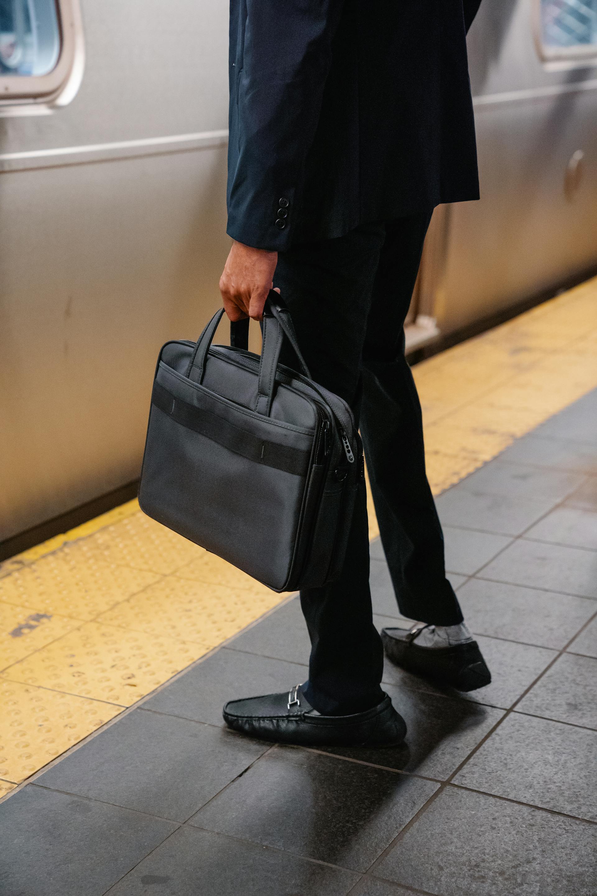 Close-up shot of a man carrying a bag while standing on a subway platform | Source: Pexels