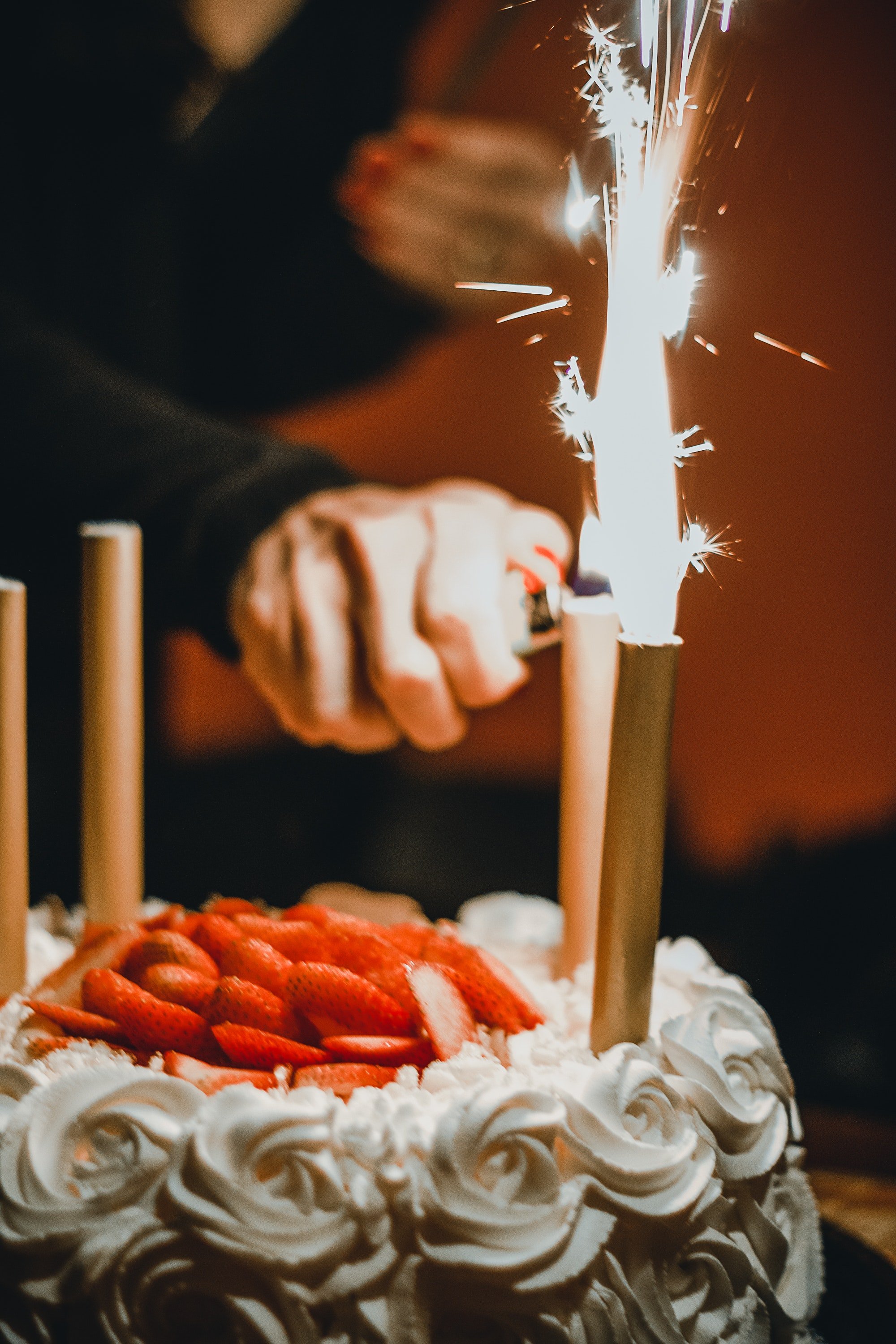 Una persona encendiendo las velas de un pastel de cumpleaños. | Foto: Pexels
