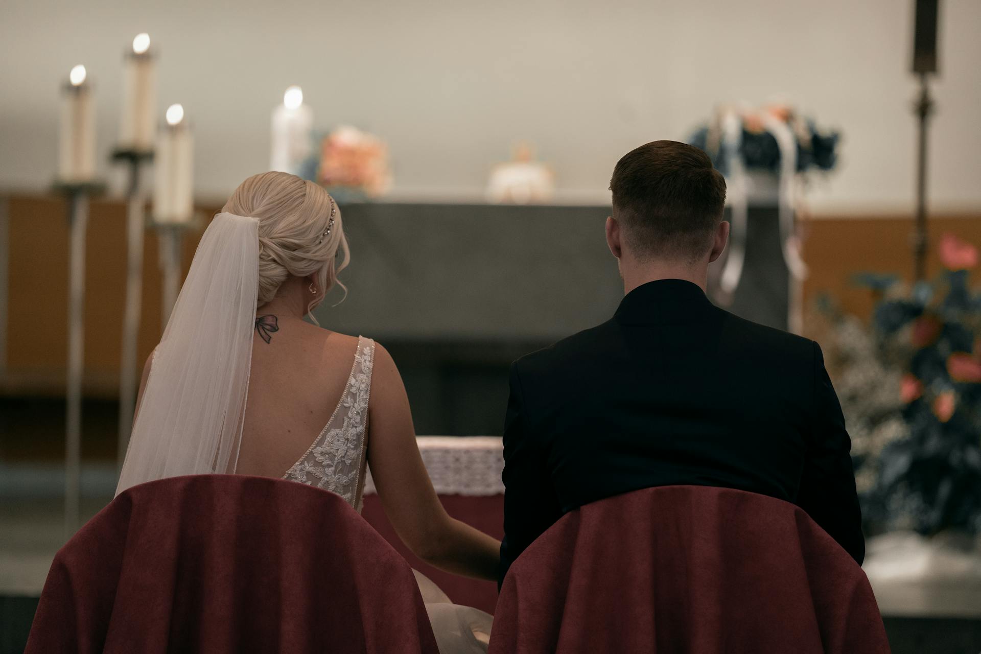 Rear view of a bride and groom seated in front of the altar | Source: Pexels