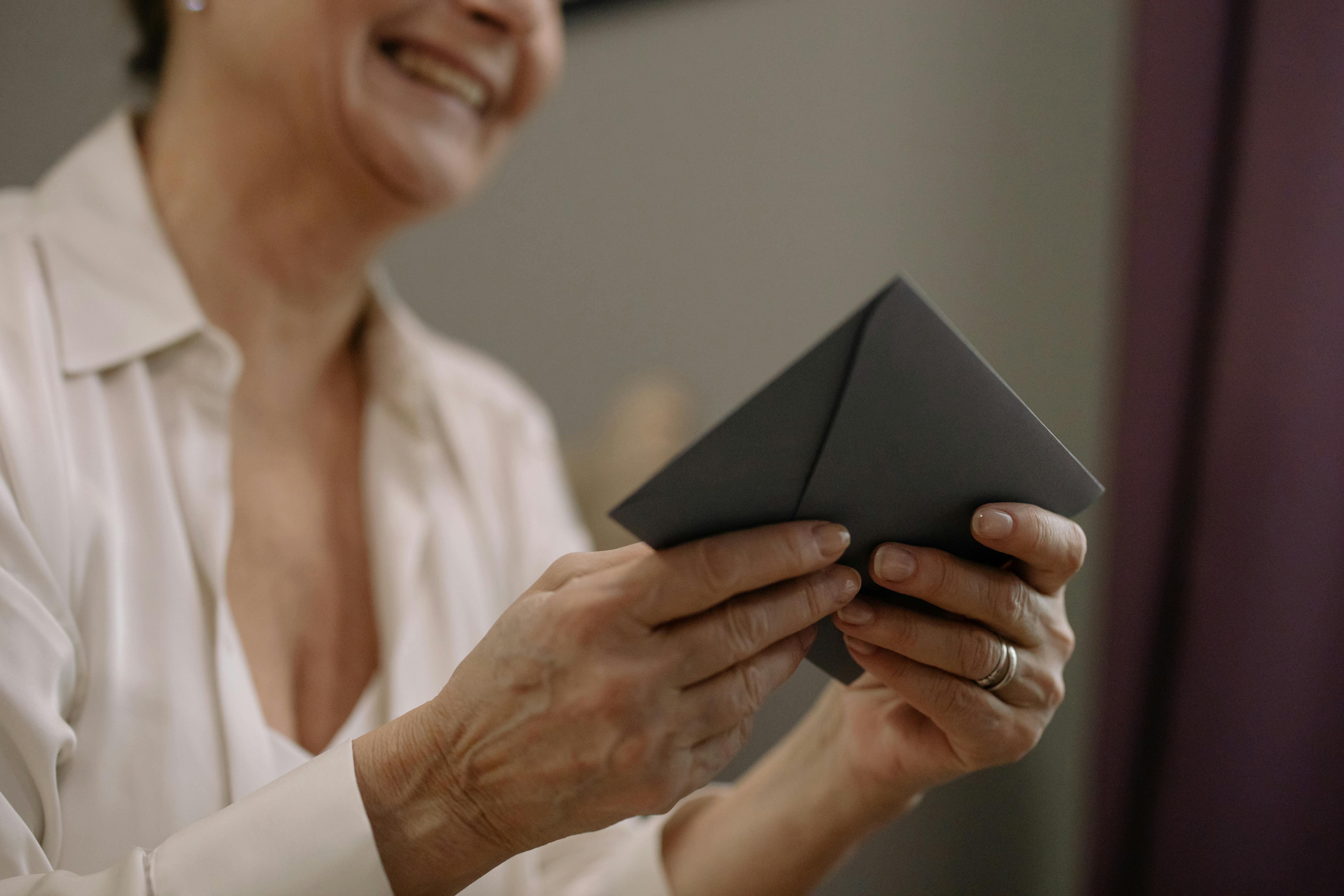 A woman holding an envelope | Source: Pexels