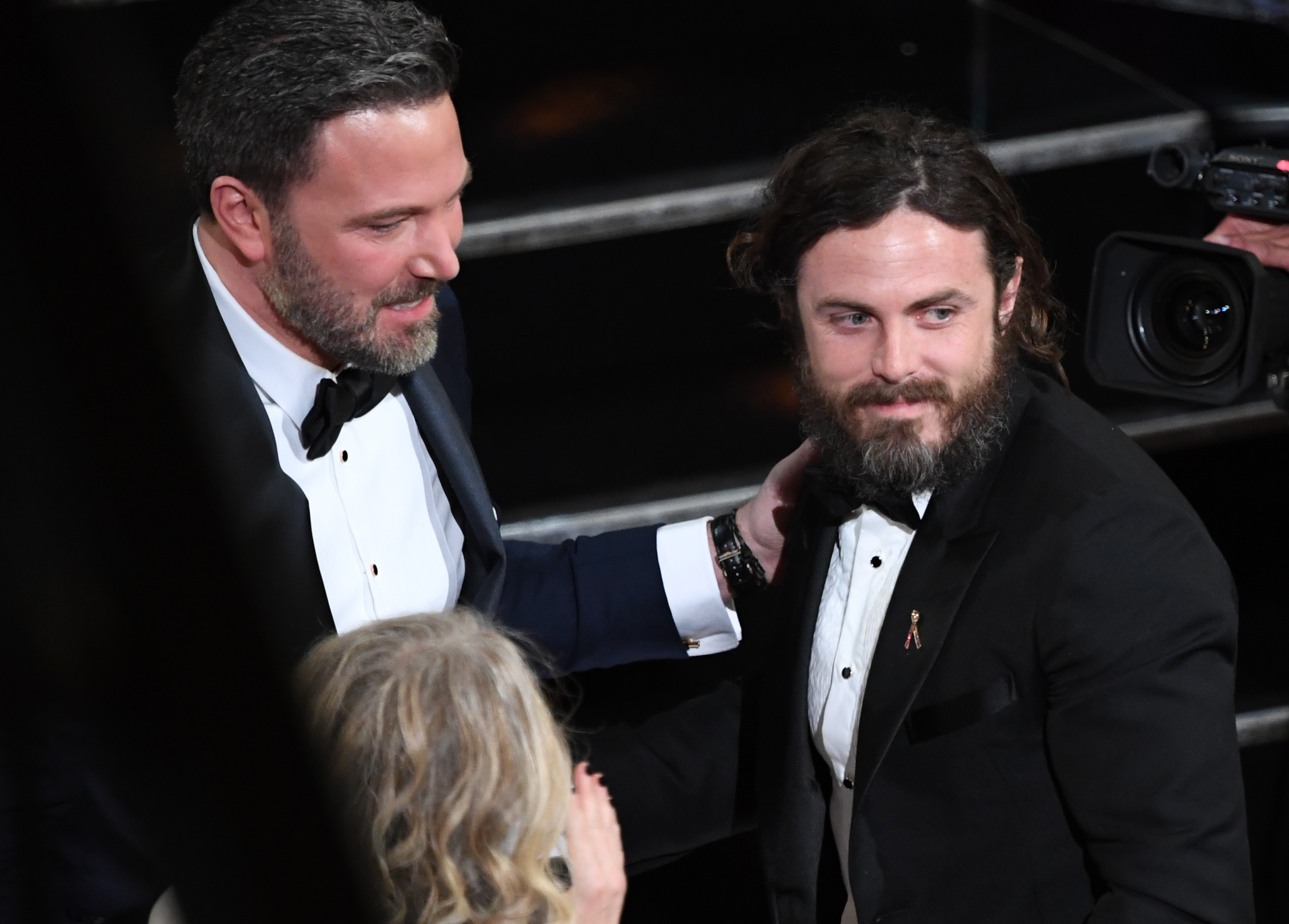 A source told People that the brothers were grieving deeply. In this photo, "Manchester by the Sea" Best Actor winner Casey Affleck was embraced by his brother Ben Affleck on stage at the 89th Academy Awards on February 26, 2017, in Hollywood, California. | Source: Getty Images