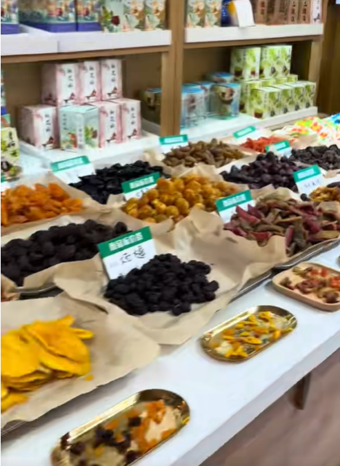 The video also shows an assortment of dried fruits, preserved foods, and packaged products arranged across a display table inside a market or specialty store during Amanda "Mandy" Karolkiewicz's trip to China. | Source: TikTok/mandykarolk