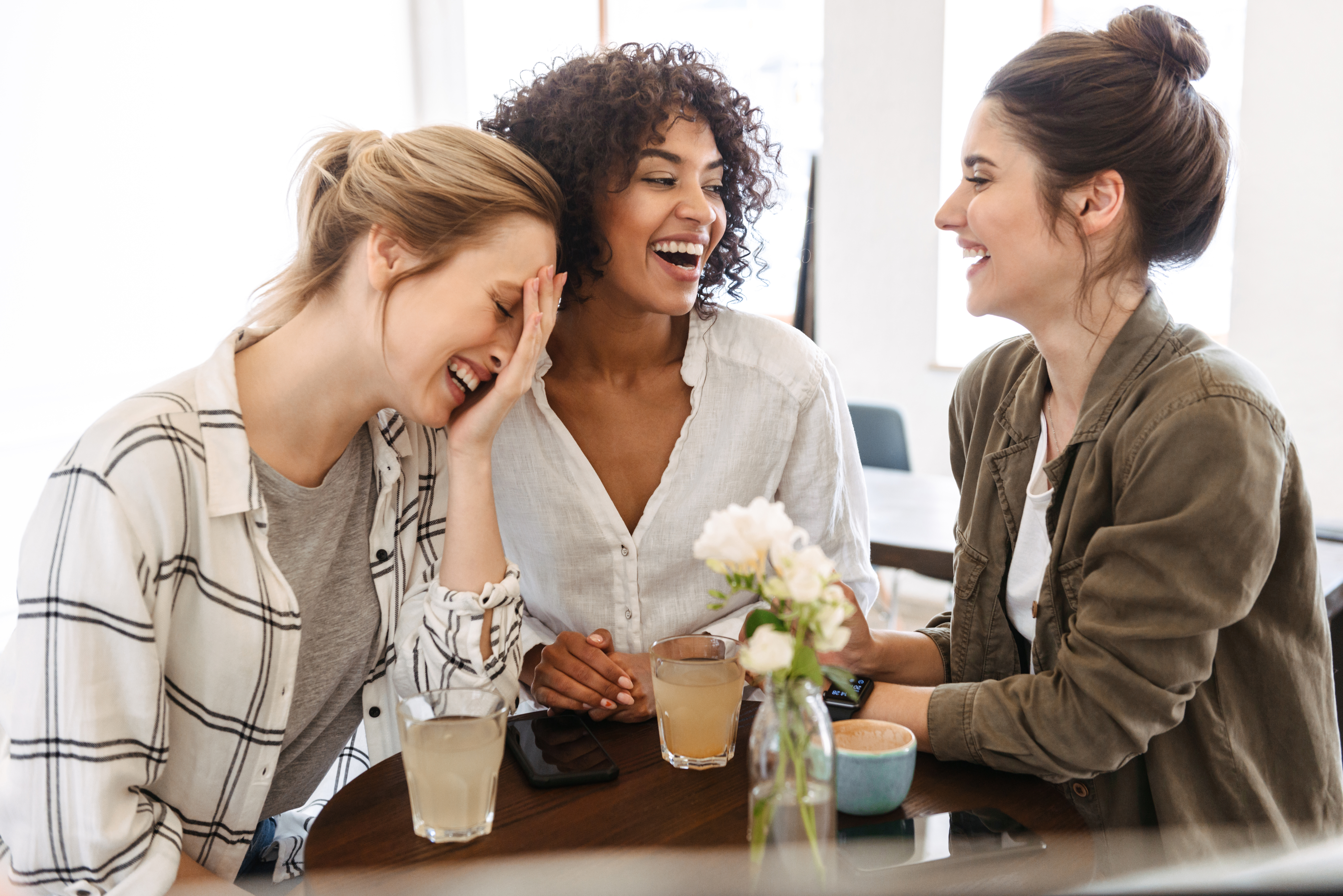 Three happy women enjoying coffee and drinks | Source: Shutterstock