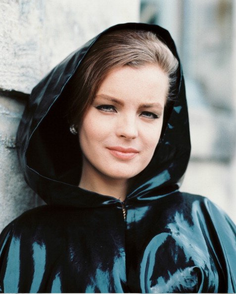 Romy Schneider, actrice autrichienne, vêtue d'un imperméable en plastique foncé, avec la capuche relevée, vers 1970. | Photo : Getty Images