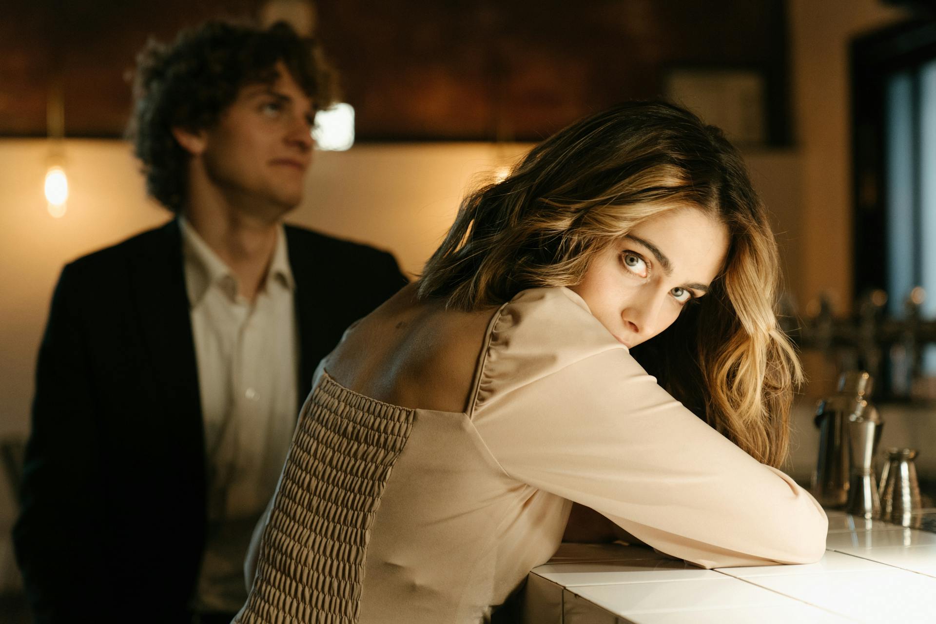 A woman looking sideways with her boyfriend standing beside her in a bar | Source: Pexels