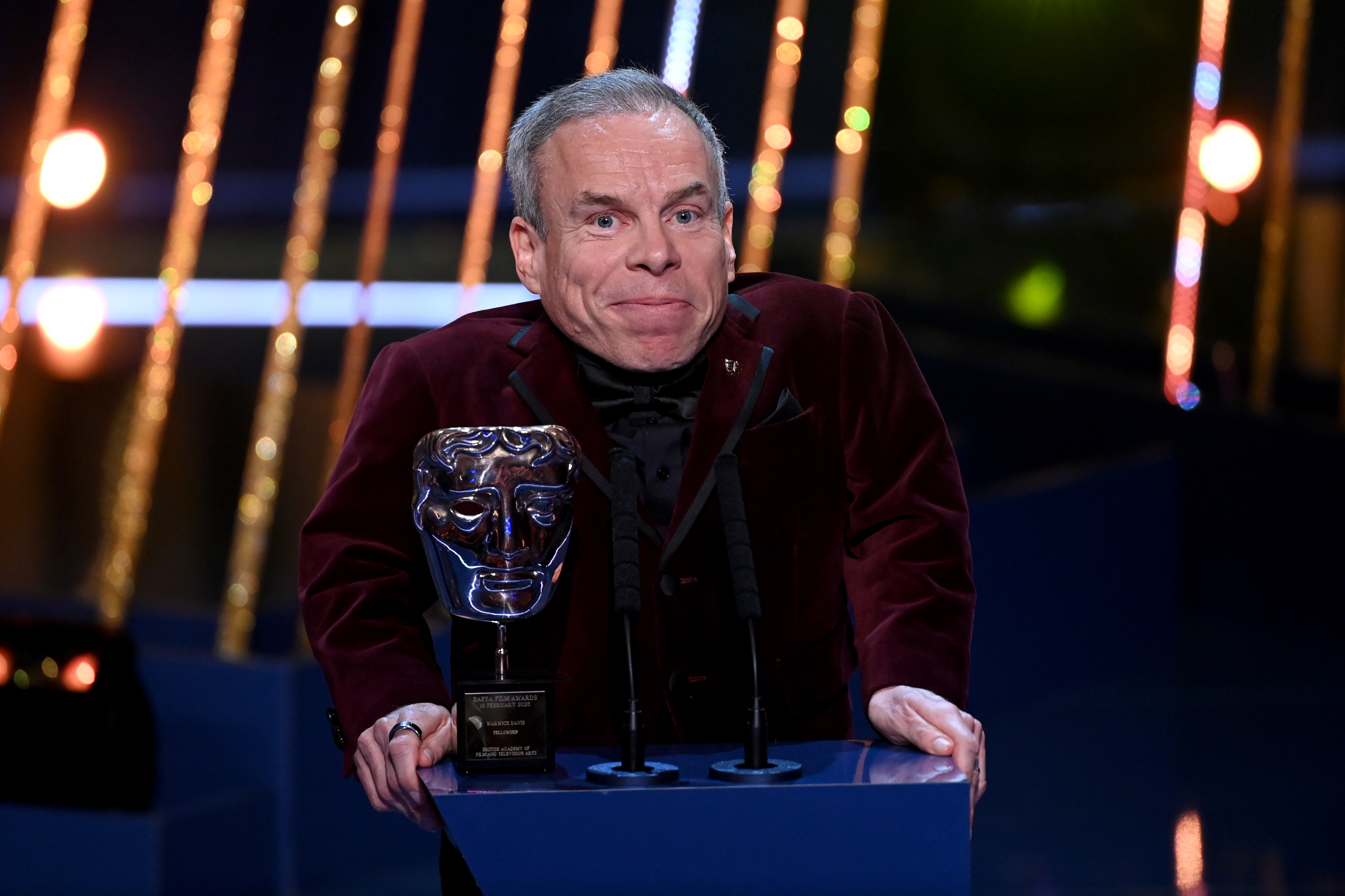 Warwick Davis accepts the Fellowship Award on stage during the EE BAFTA Film Awards 2025 at The Royal Festival Hall on 16 February in London, England. | Source: Getty Images