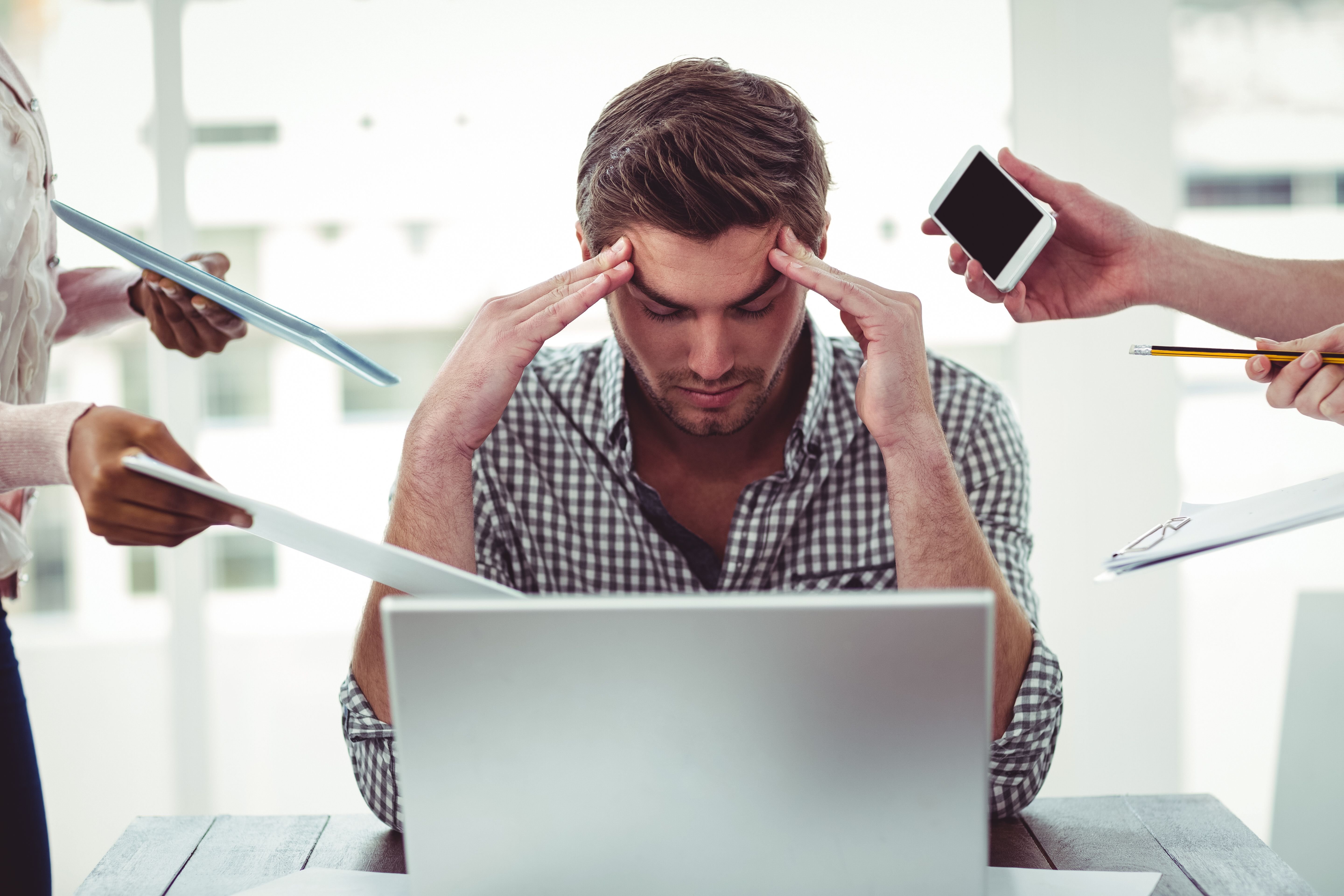 A man looking stressed while working on his laptop. | Source: Shutterstock