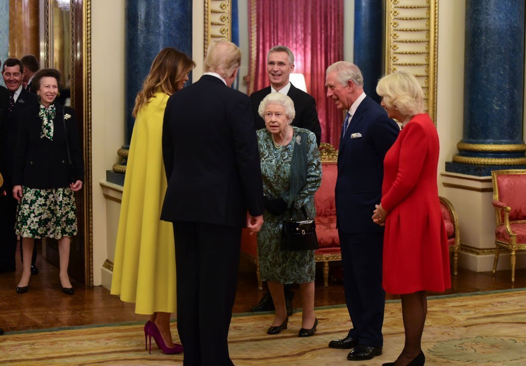 Queen Elizabeth II talks to US President Donald Trump and wife Melania as she hosts a reception for NATO leaders at Buckingham Palace | Photo: Getty Images