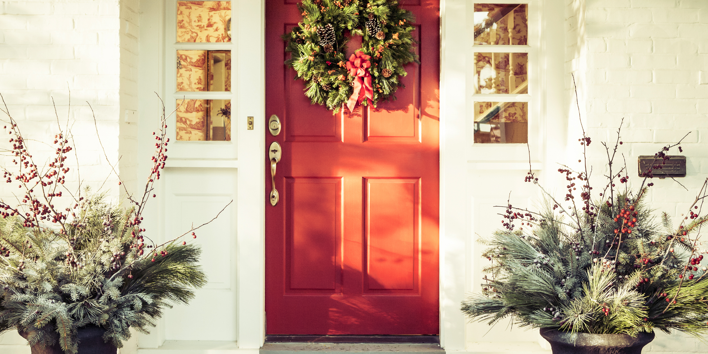A red door decorated for Christmas | Source: Getty Images