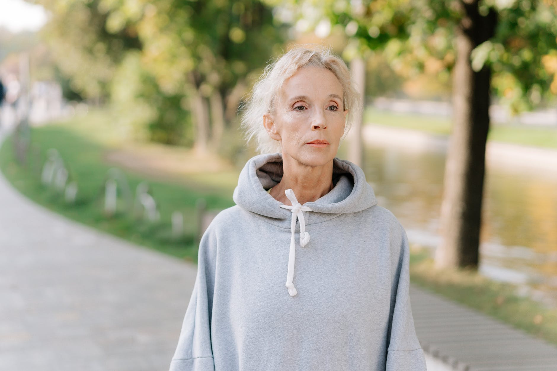 Una mujer mayor con expresión perdida camina por el parque. | Foto: Pexels