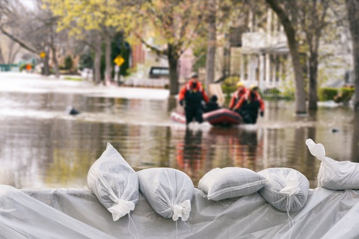 Helfer mit Schlauchboot in überfluteter Straße | Quelle: Getty Images