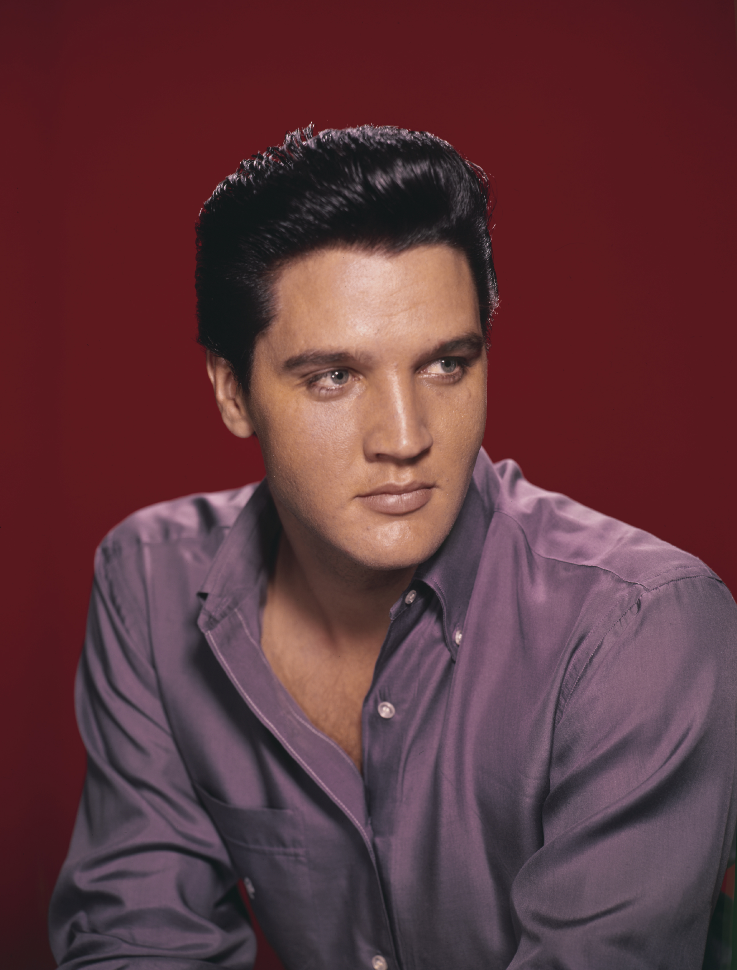 A portrait of American singer and actor Elvis Presley wearing a purple shirt circa 1956. | Source: Getty Images