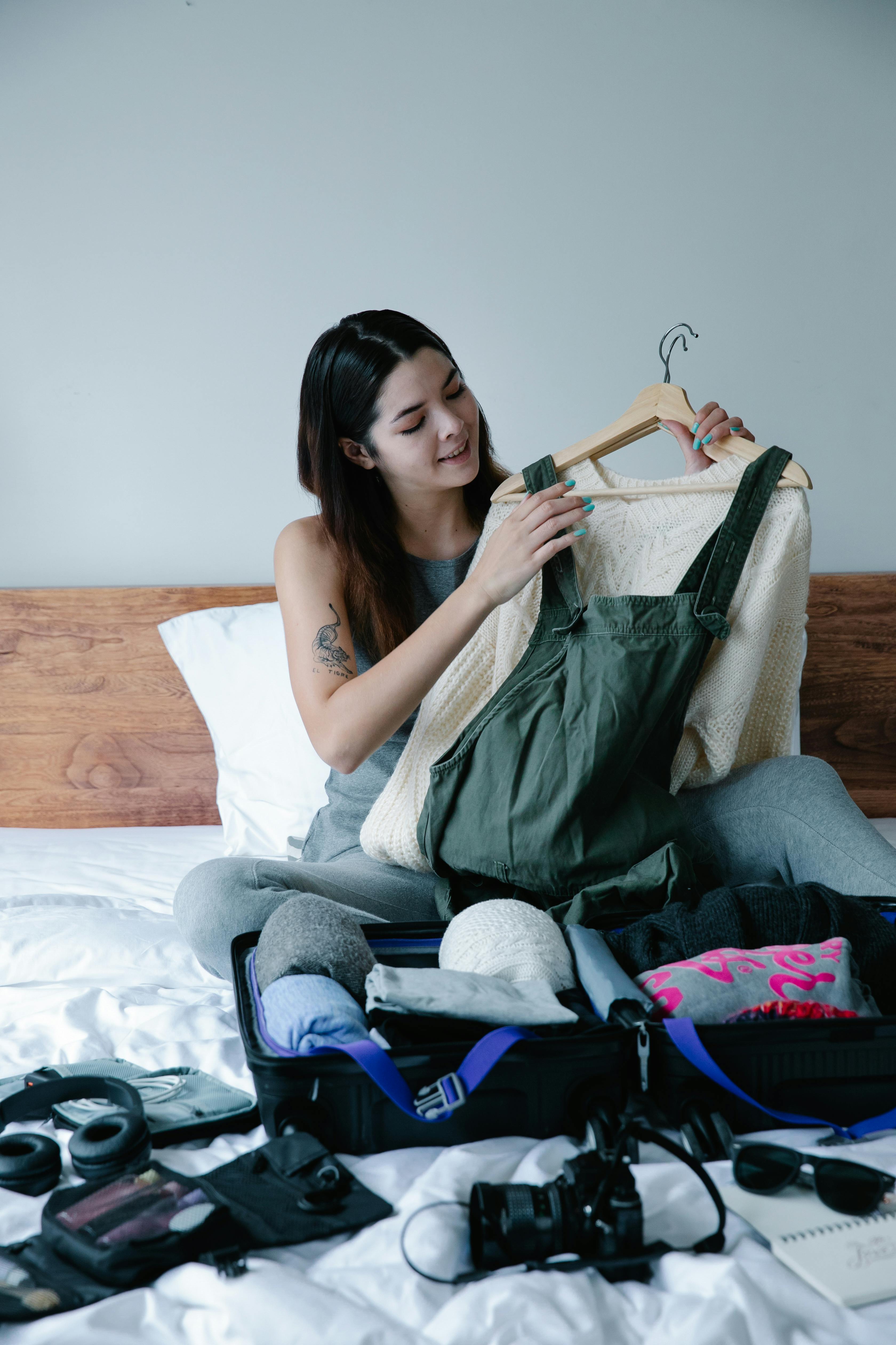 A woman looking at clothes on a hanger | Source: Pexels