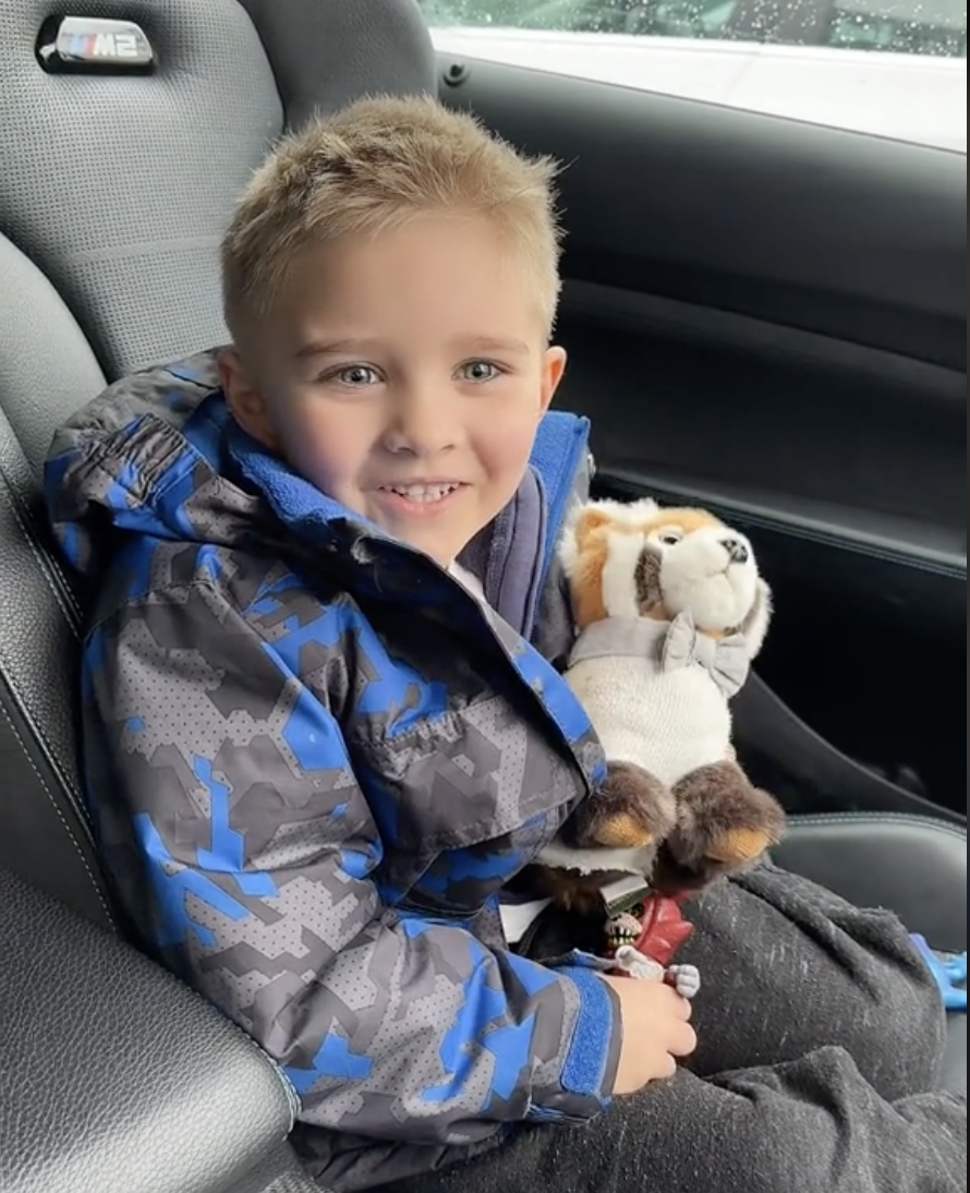 Tom's son, Roman, is pictured sitting in the car with his stuffed toy. | Source: tiktok.com/@tom_leeds