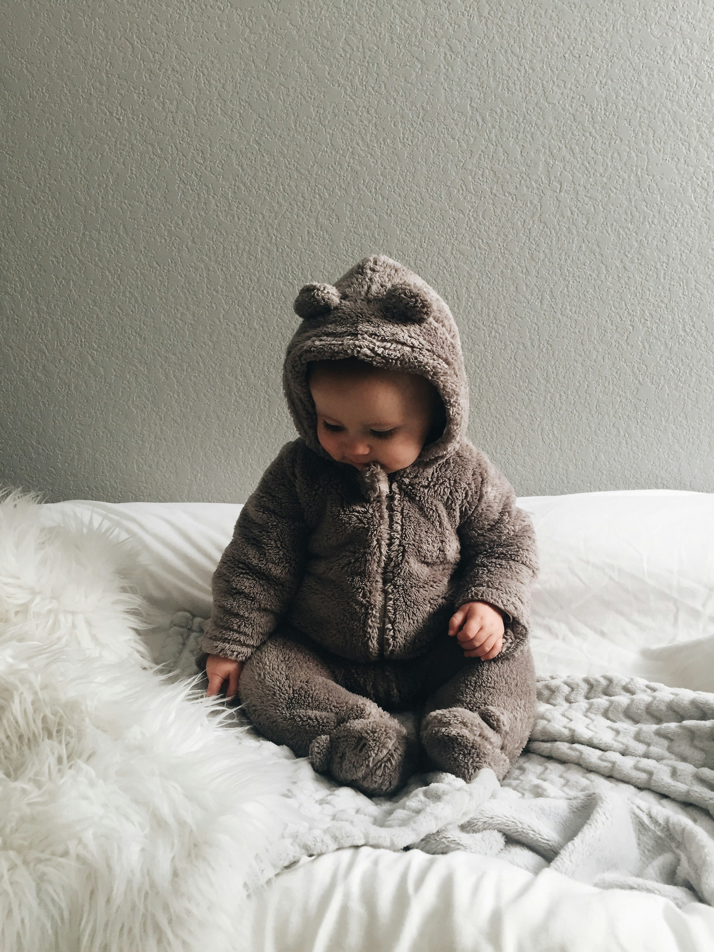 A cute baby sitting on the bed | Source: Unsplash