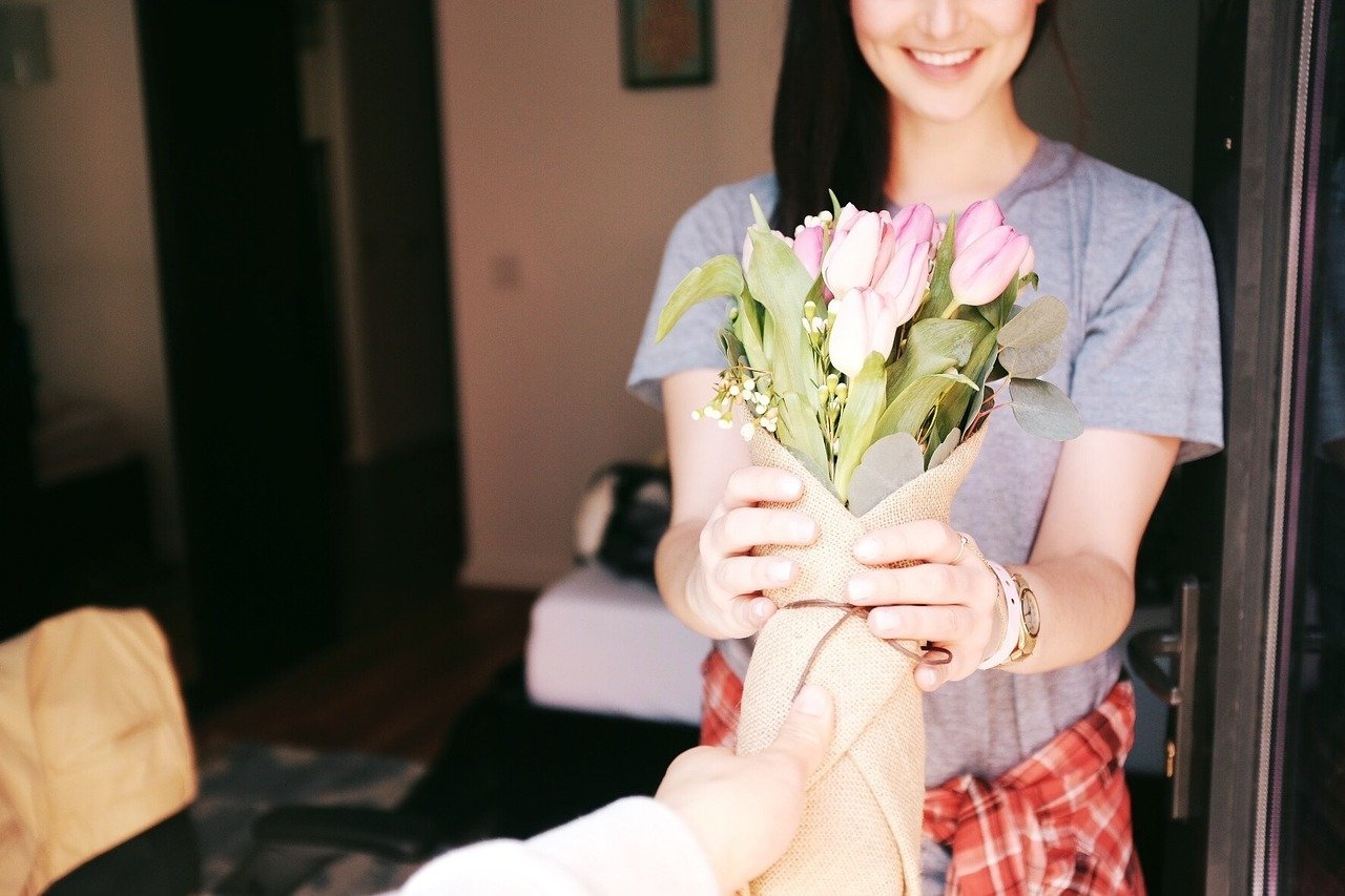 Woman receiving a bouquet of flowers. Image credit: Pixabay. 