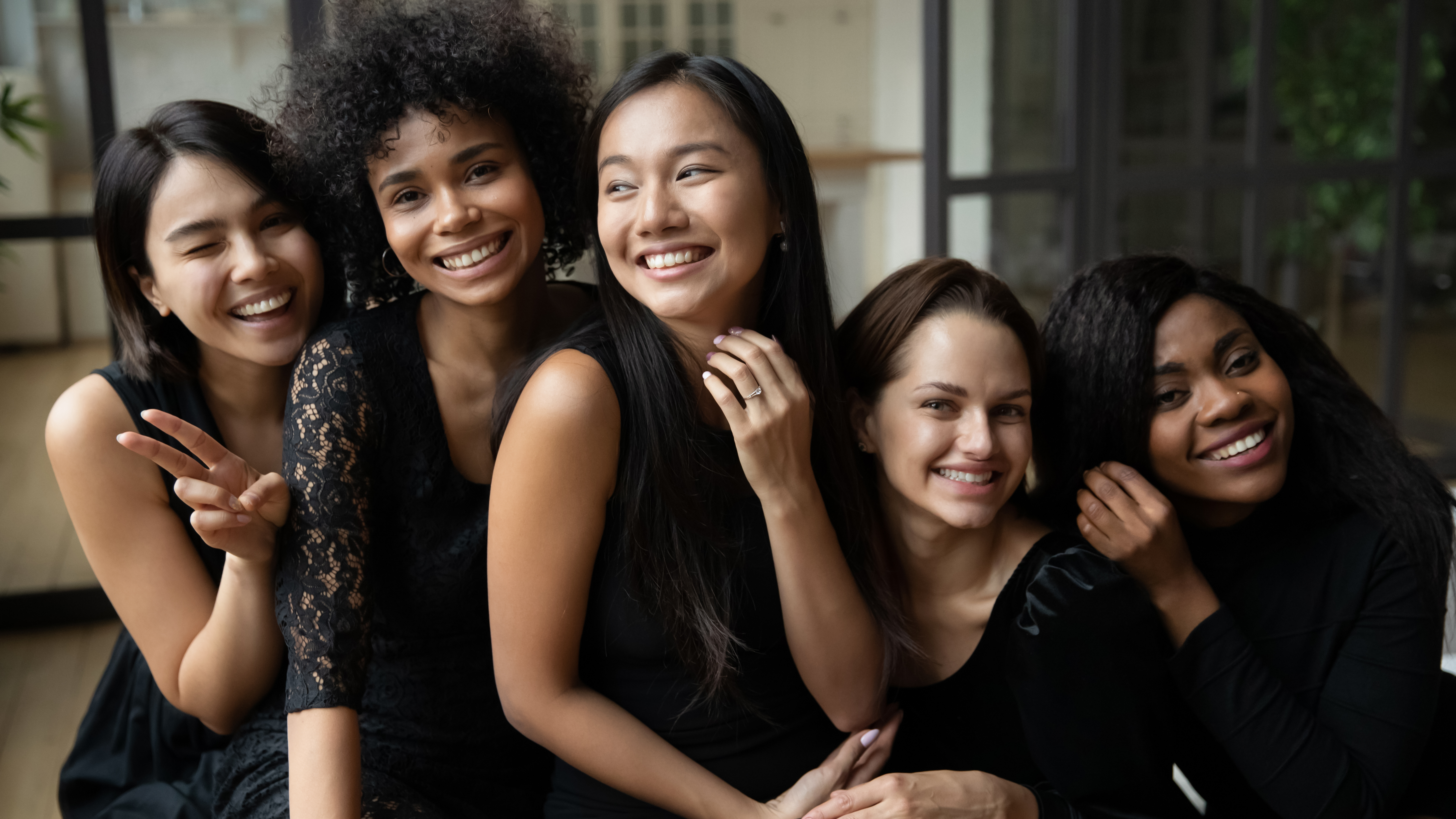 Women in black smiling while standing together | Source: Shutterstock