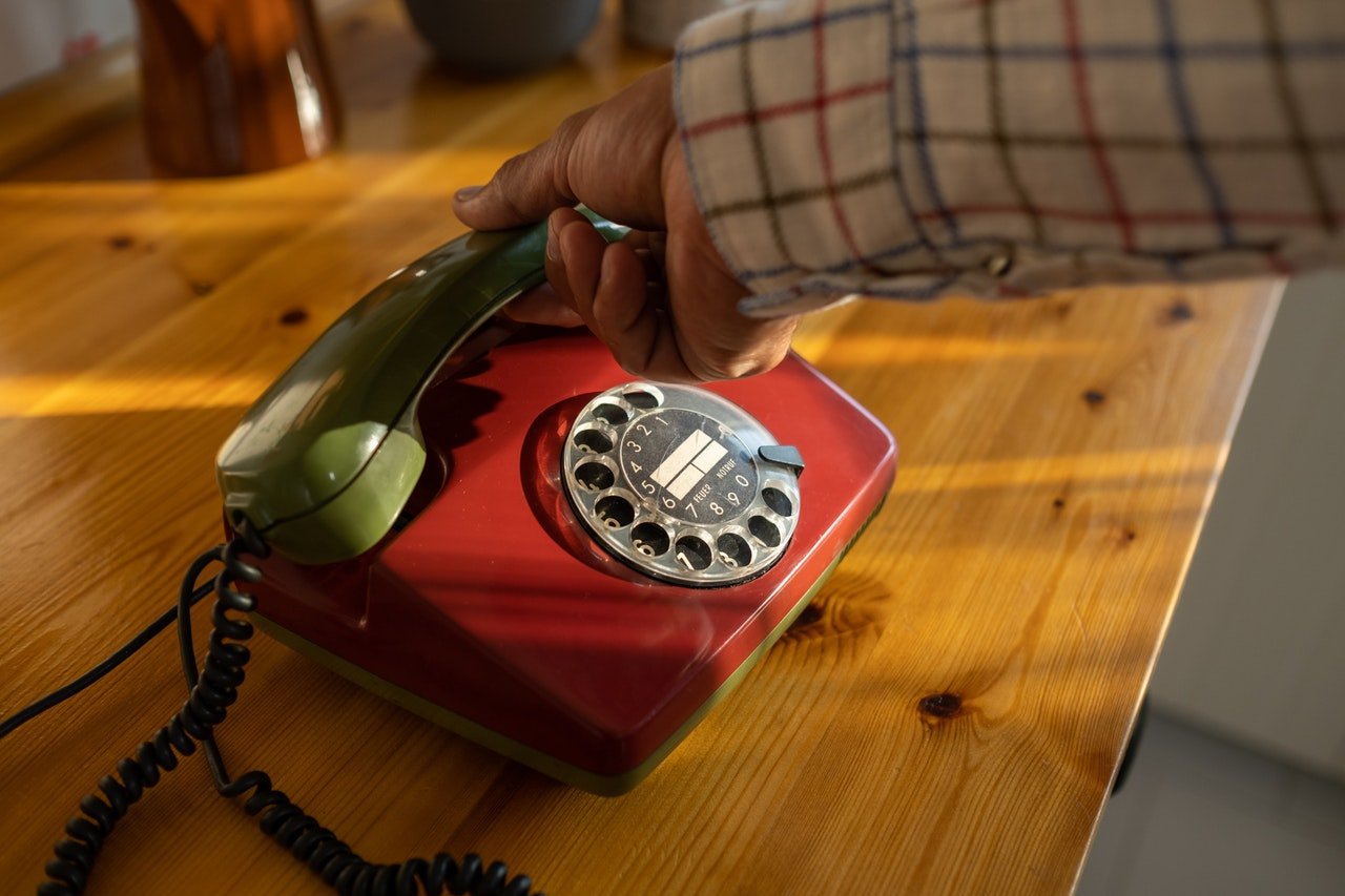 An old telephone set lying on a wooden surface | Source: Pexels