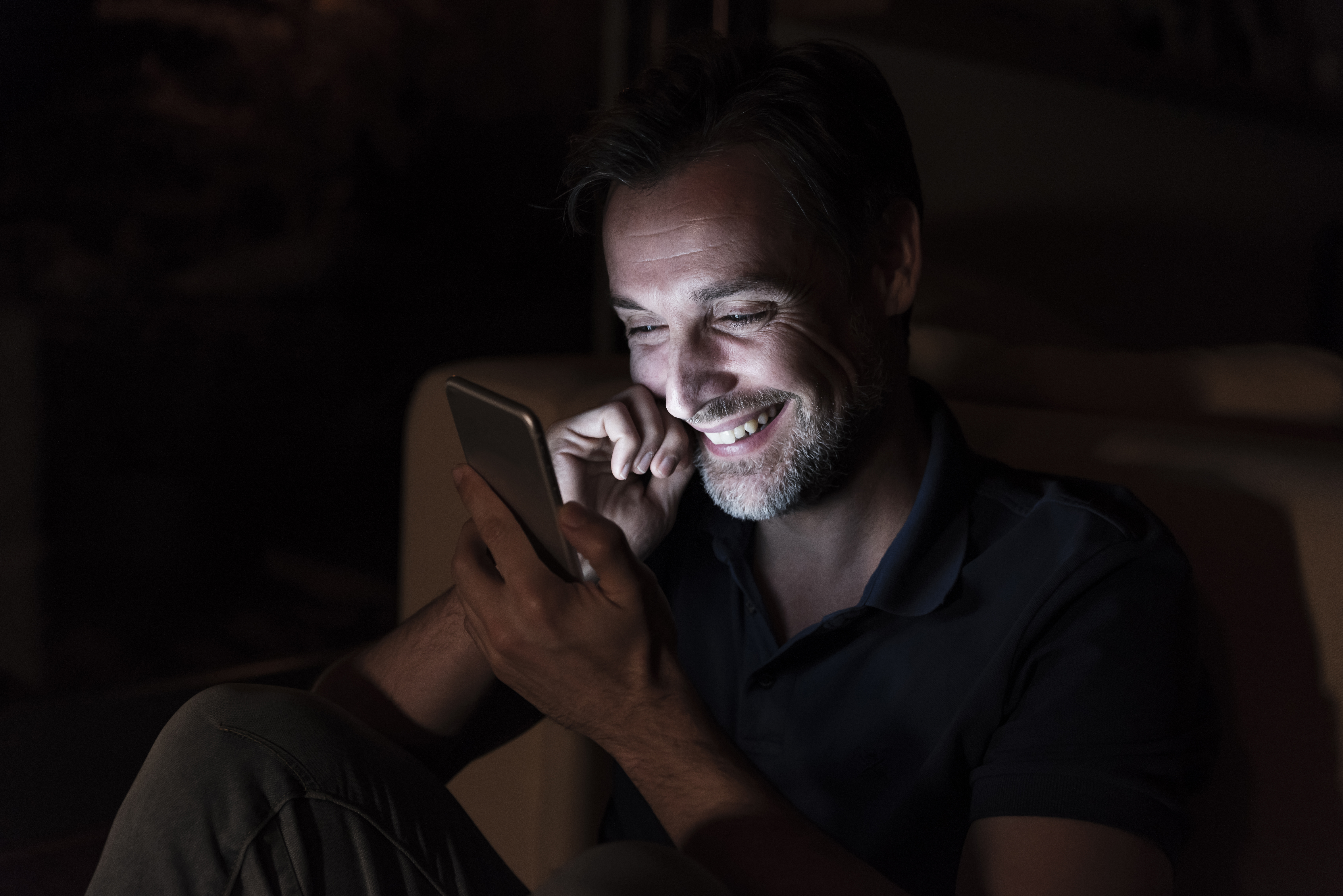 Man laughing while texting | Source: Getty Images