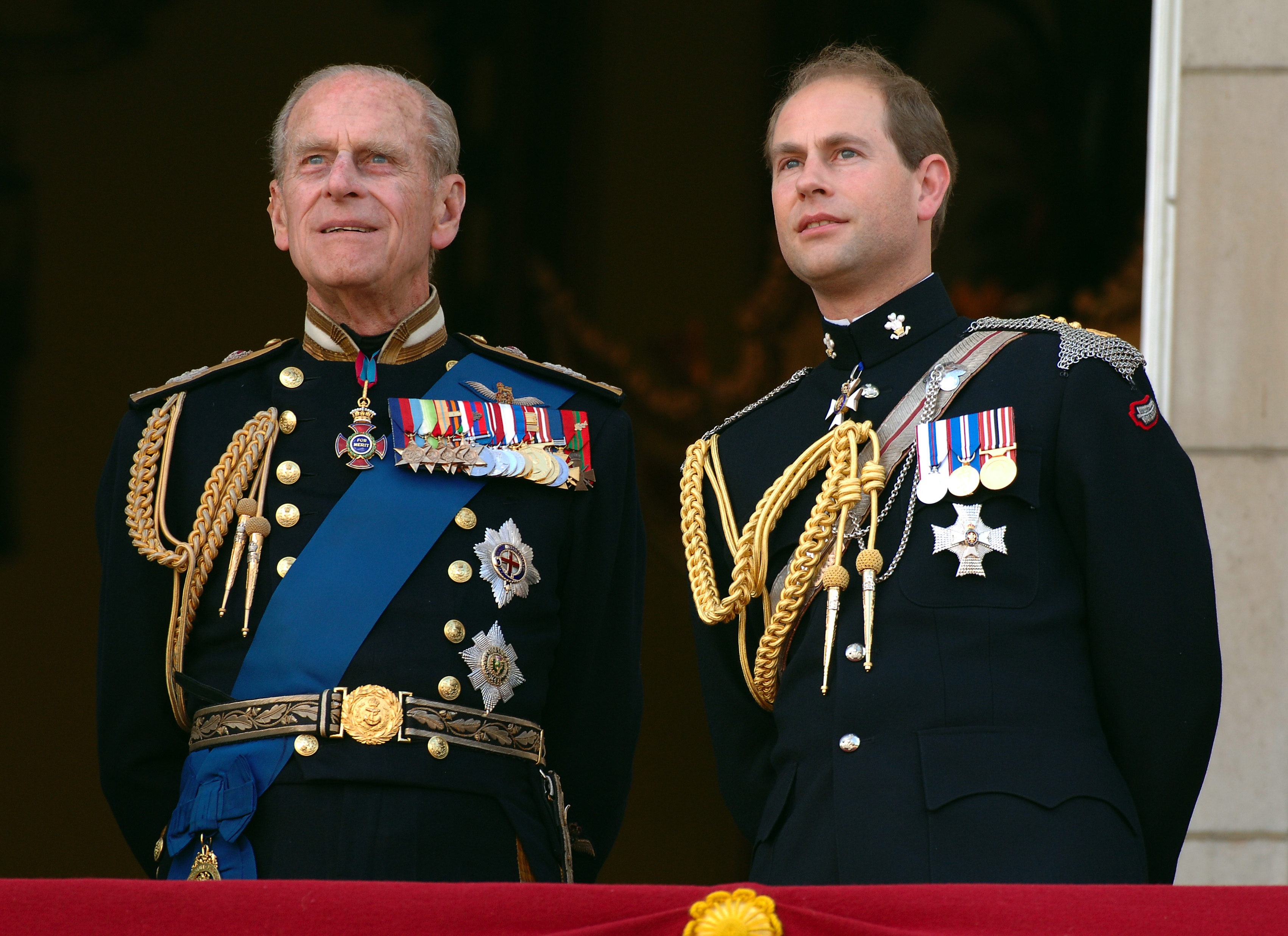 Prince Edward, then-Earl of Wessex and Prince Philp, then-Duke of Edinburgh watch the flypast over the Mall of British and US World War II aircraft from the balcony of Buckingham Palace on National Commemoration Day on 10 July 2005 in London, England. | Source: Getty Images