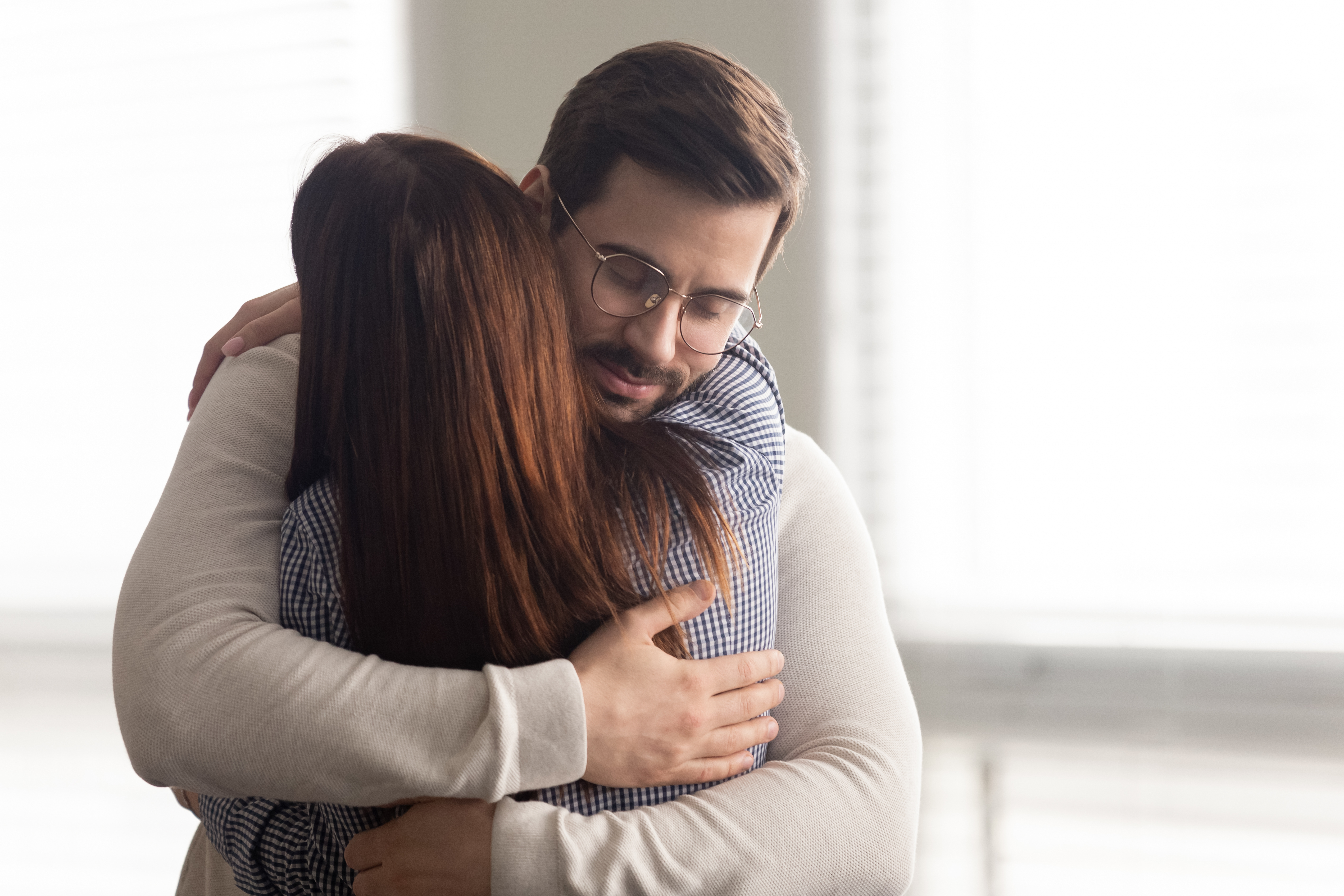 Handsome man embracing woman. | Source: Shutterstock