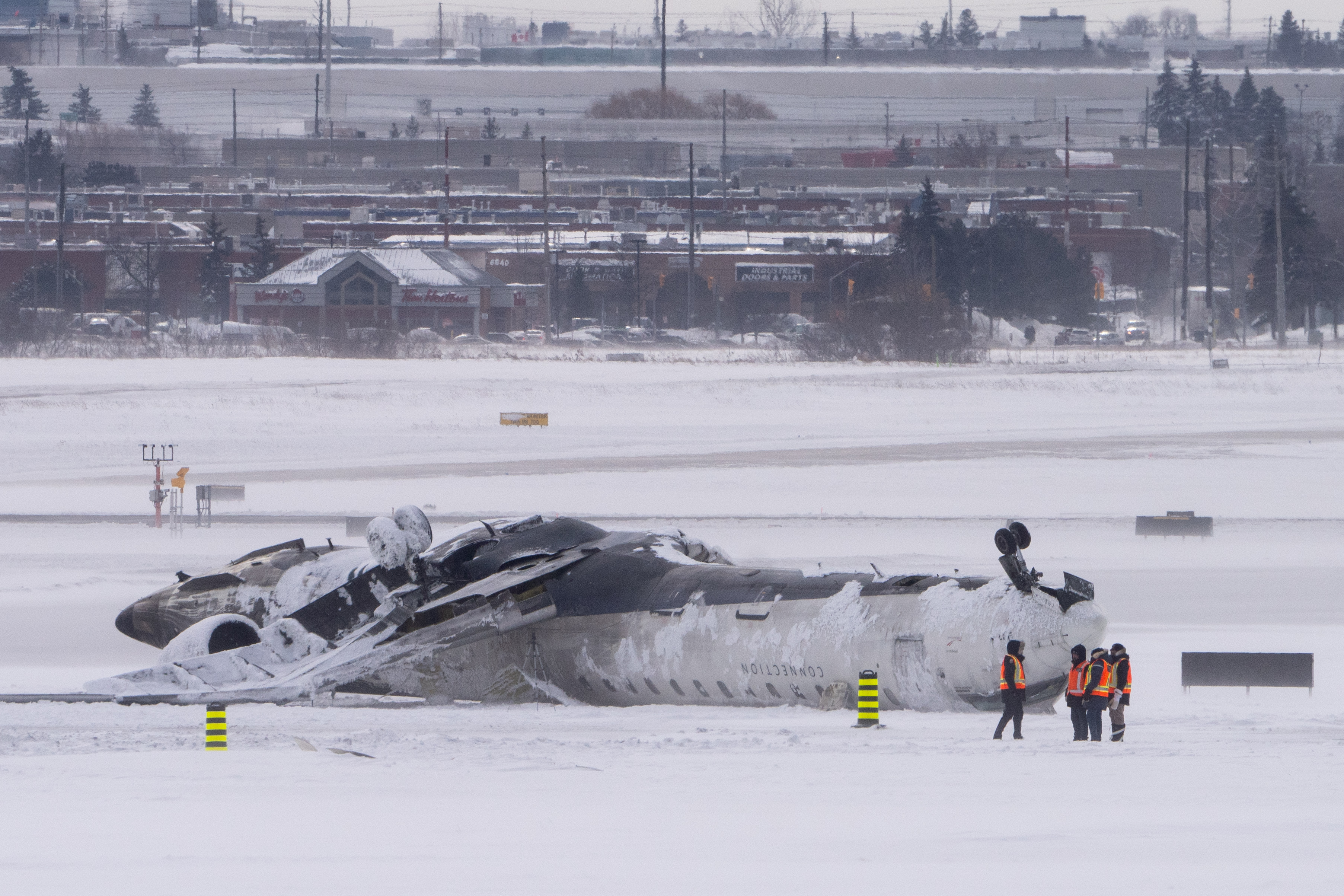 Airport workers surveying the plane after it crashed. | Source: Getty Images