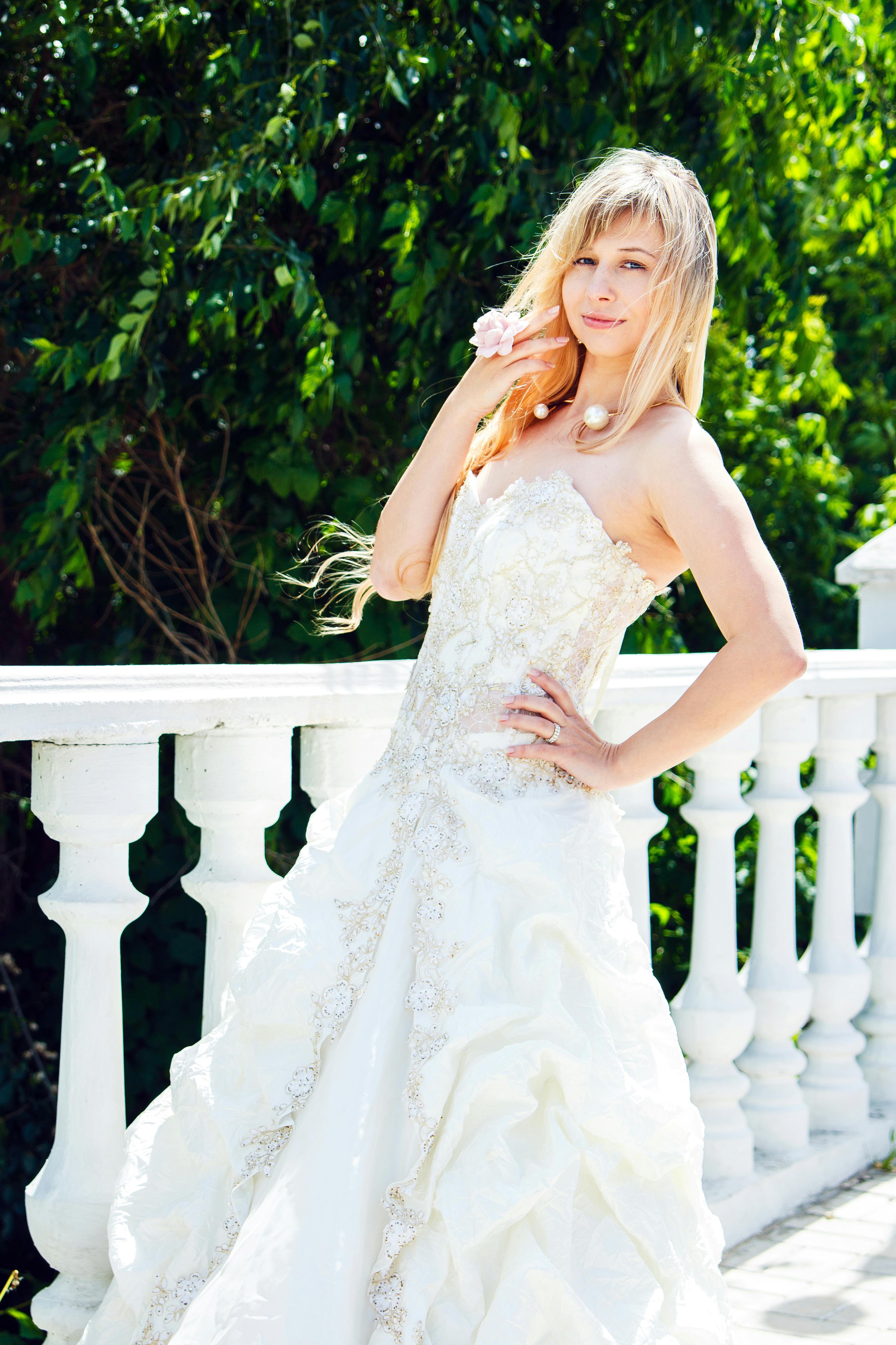 A woman smiling while dressed in a wedding gown | Source: Pexels