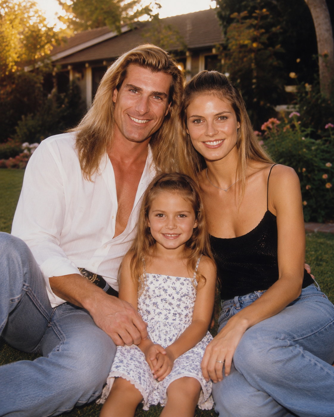 An AI-imagined family portrait shows Fabio and Heidi Klum sitting on the grass with their young daughter, dressed in casual denim and light tops for a warm celebrity lifestyle shot. | Source: ChatGPT