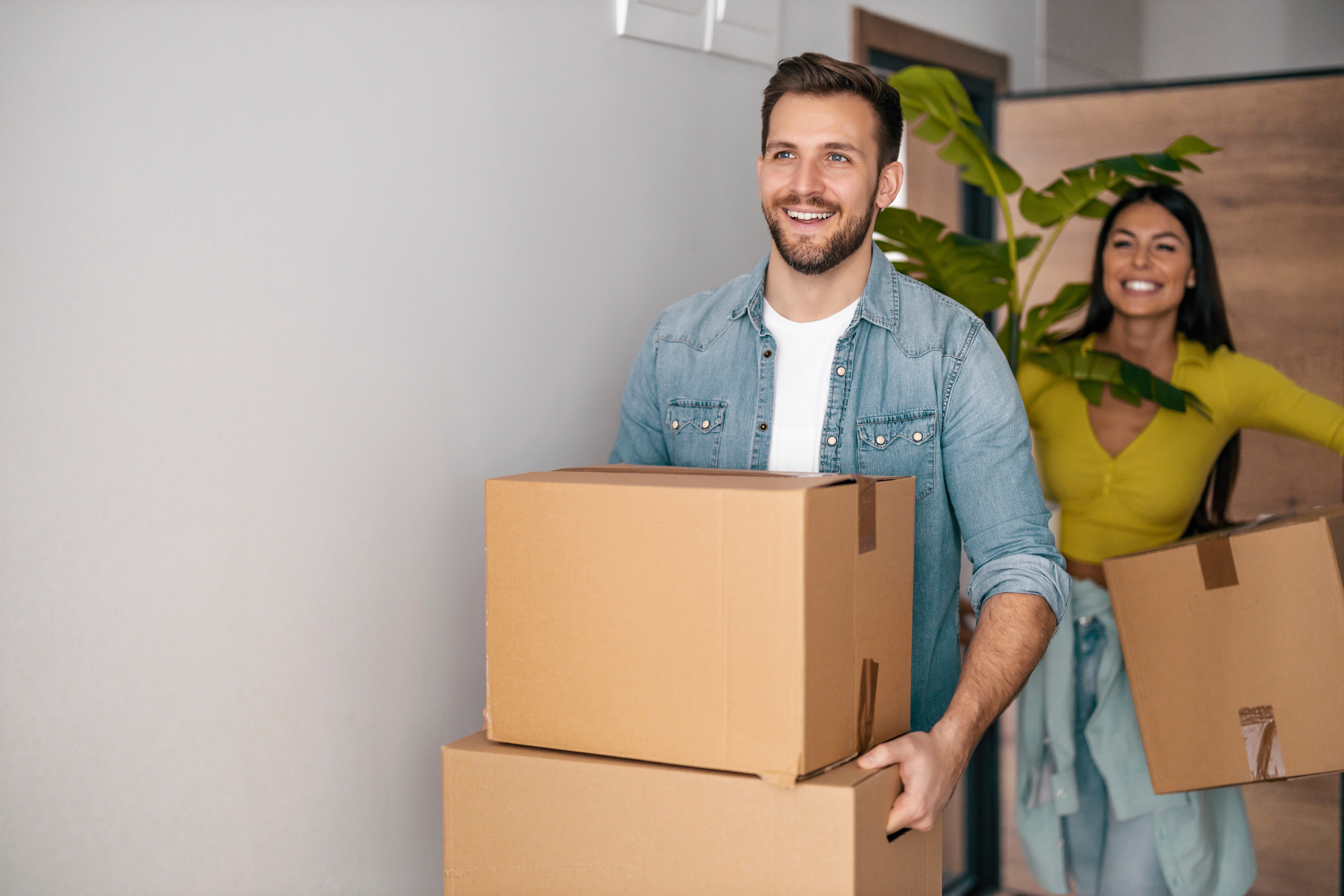 A happy young couple with cardboard boxes in their new home. | Source: Shutterstock