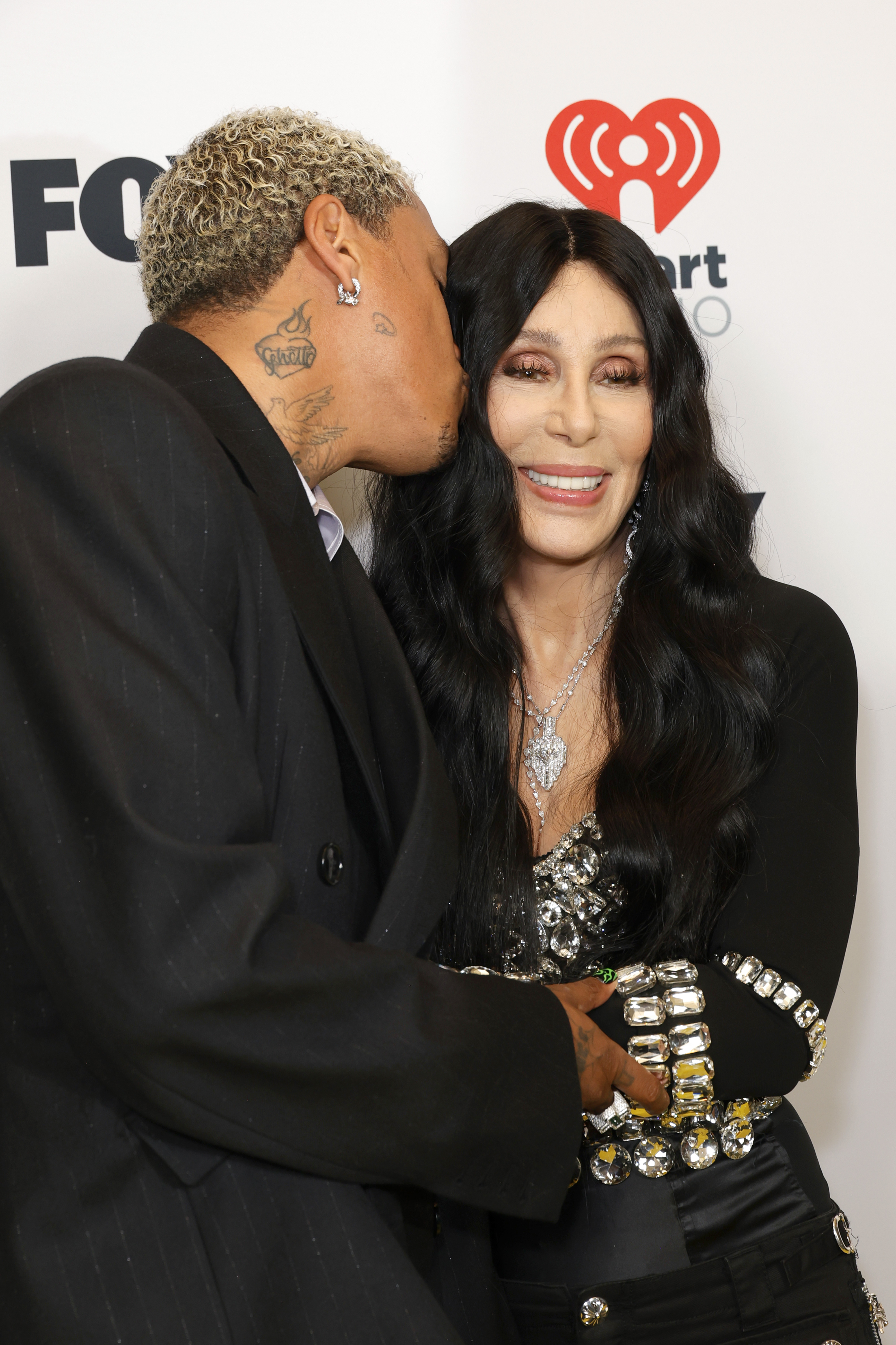 Alexander "AE" Edwards kisses Cher on the cheek at the 2024 iHeartRadio Music Awards on April 1, 2024 in Hollywood, California. | Source: Getty Images