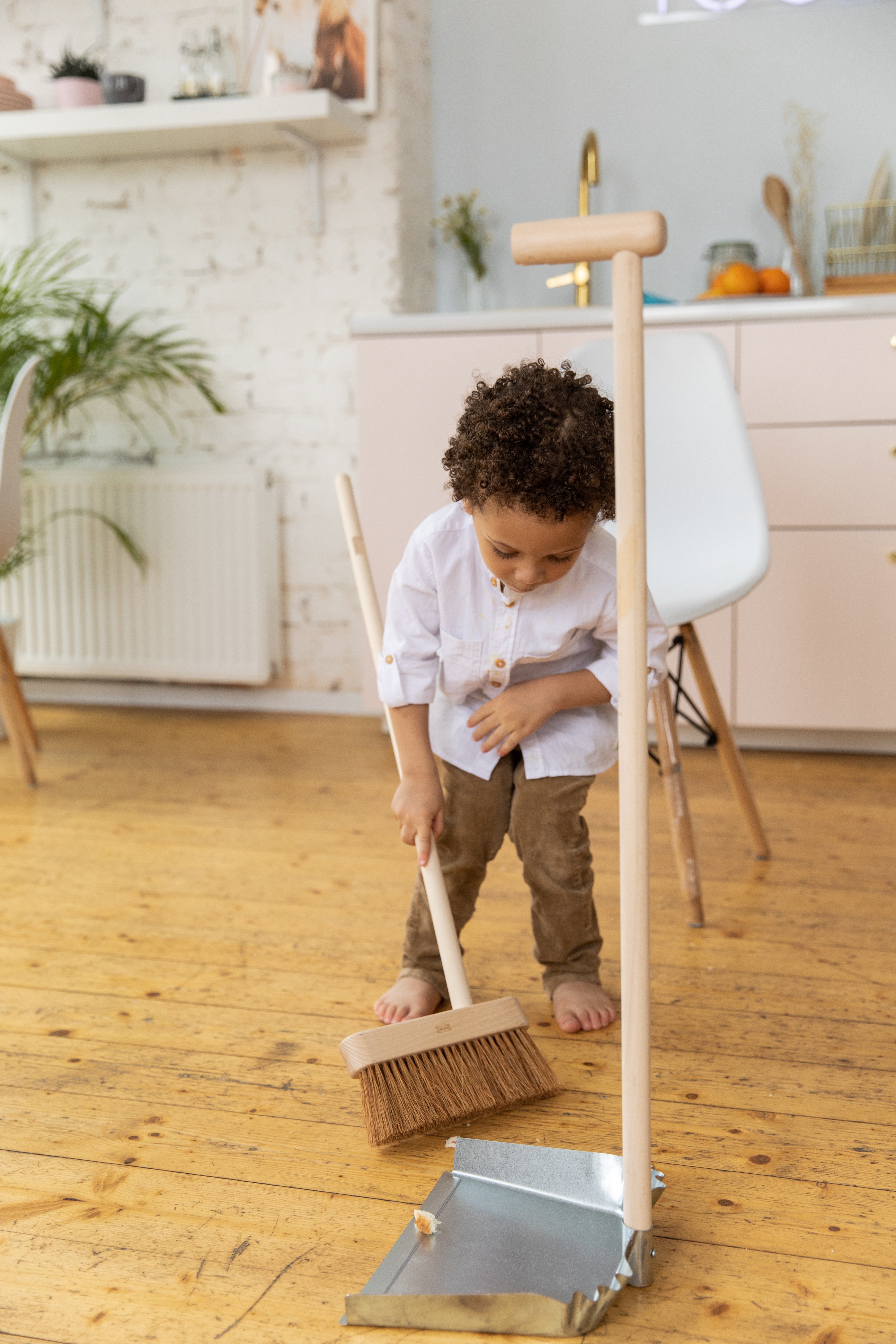 Niña barriendo el suelo. | Foto: Pexels