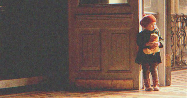 A little girl by the door of a room | Source: Shutterstock