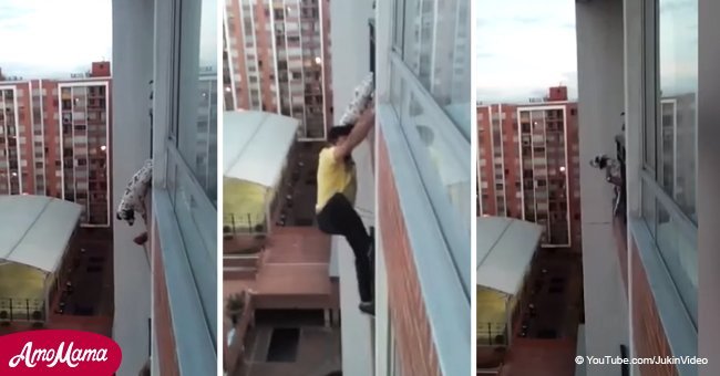 Chilling moment man climbs to the 13th floor to save a dog hanging from a balcony