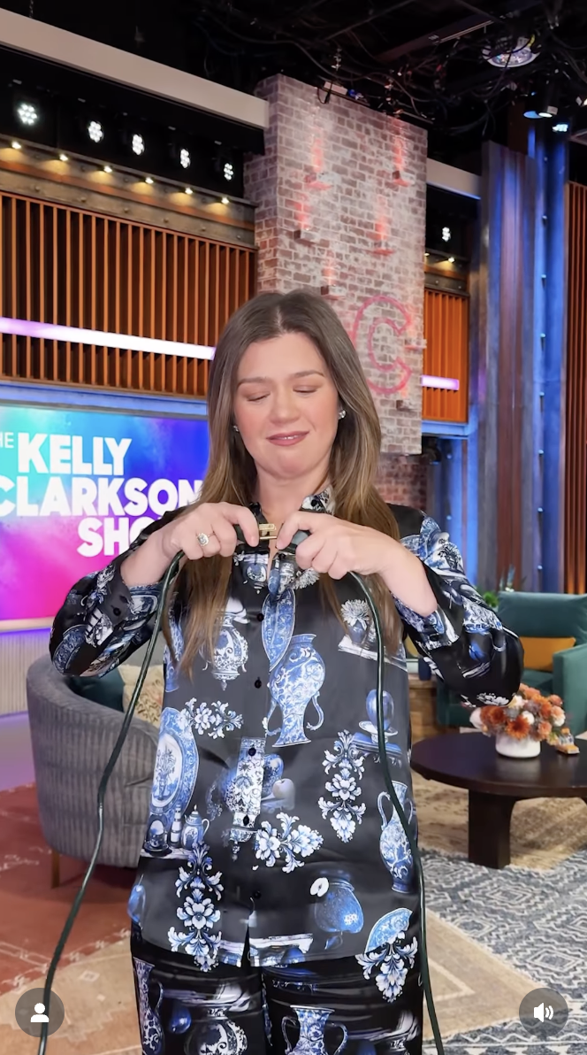 Kelly Clarkson is seen plugging in two wires on her show, in a video dated December 10, 2025 | Source: Instagram/kellyclarksonshow