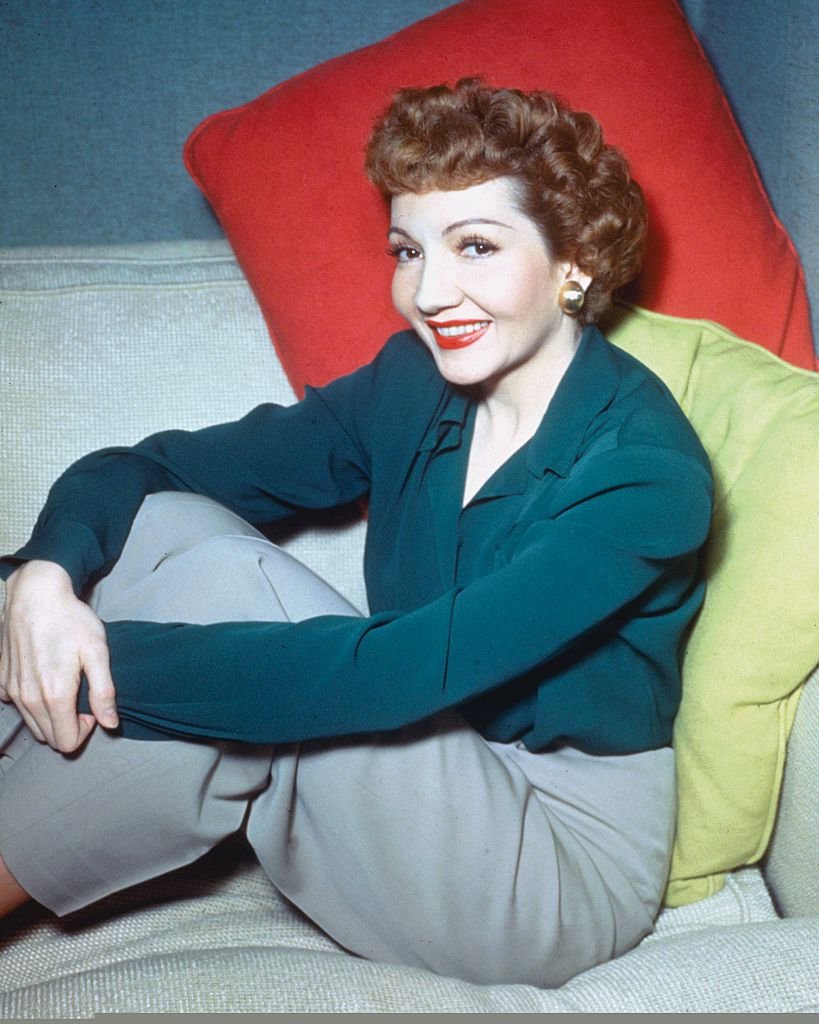 French-born US actress, Claudette Colbert, wearing a blue blouse and grey trousers in a studio portrait, circa 1950 | Photo: Getty Images