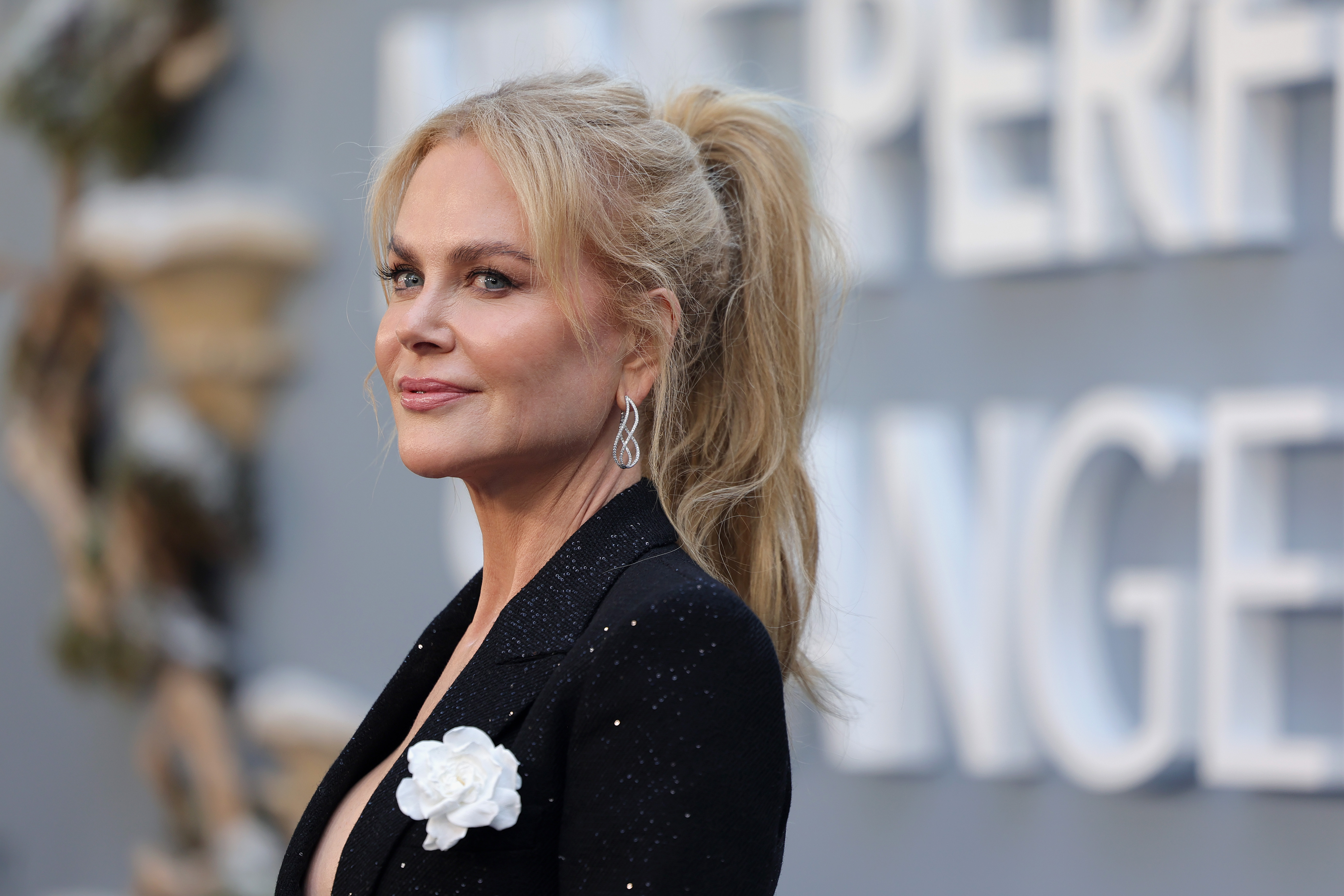 Flashing a soft smile, she glances over her shoulder, radiating grace and timeless Hollywood charm.