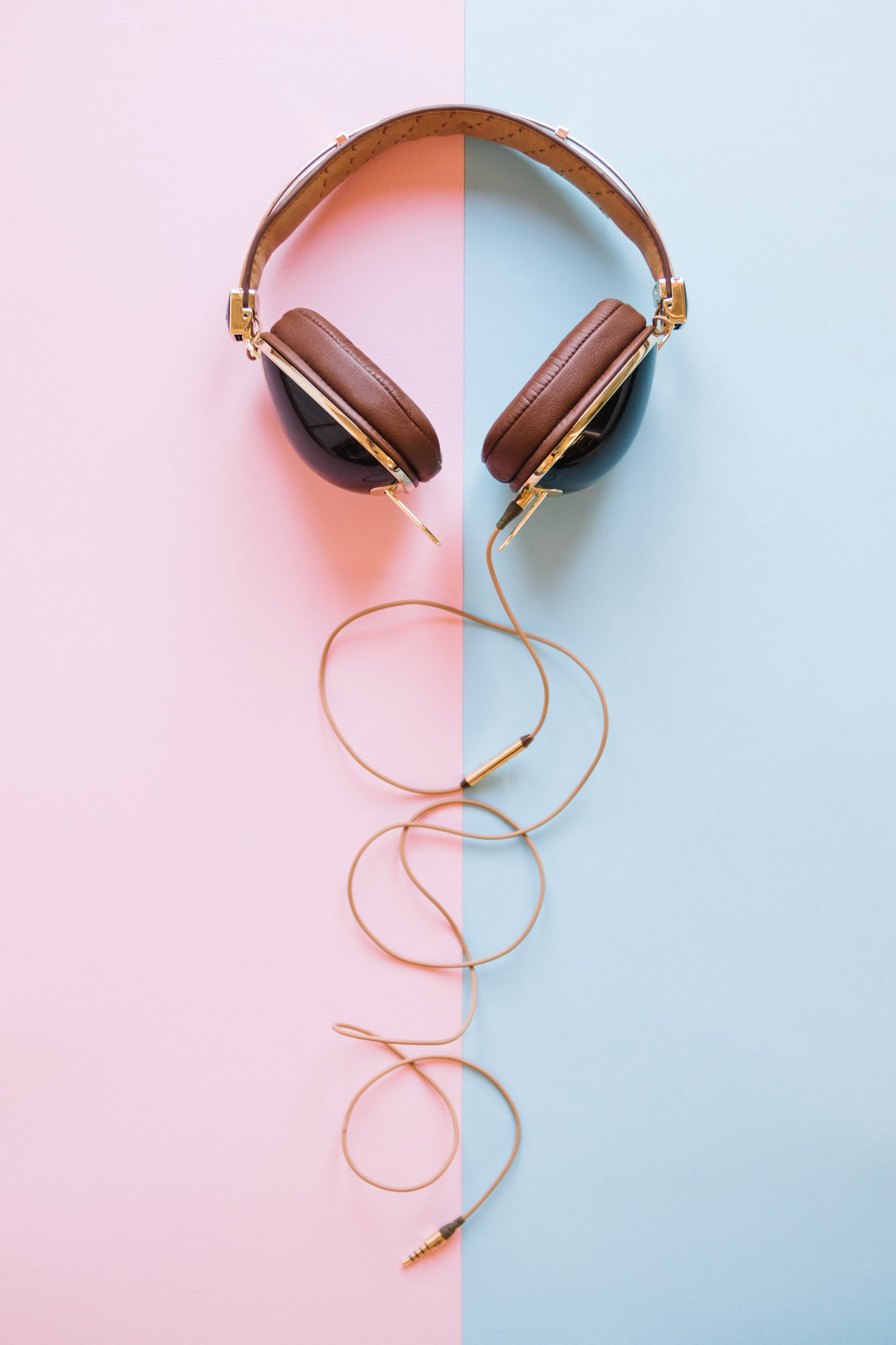 Auriculares sobre un fondo rosa y azul | Fuente: Freepik