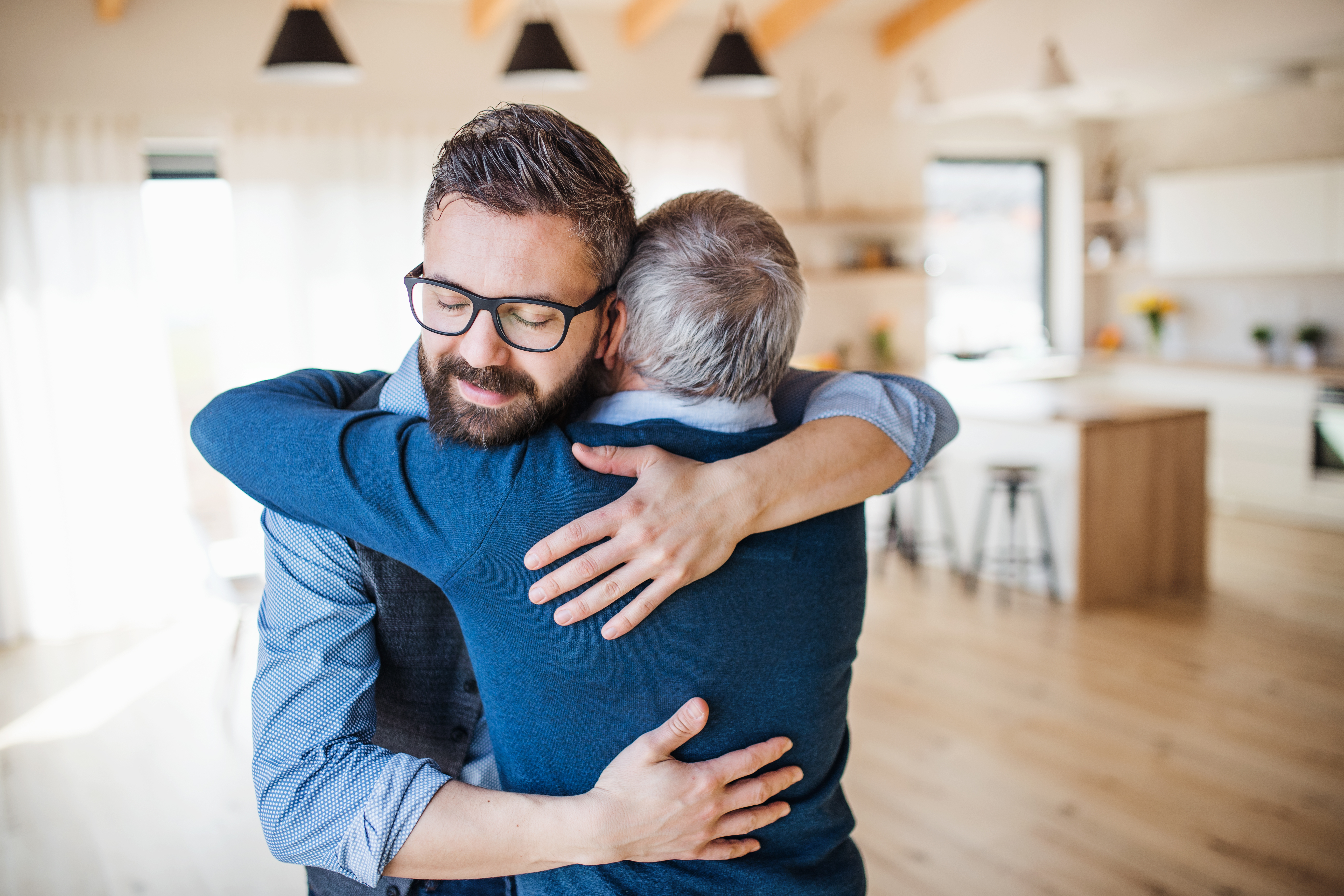 A man hugging an older man | Source: Shutterstock