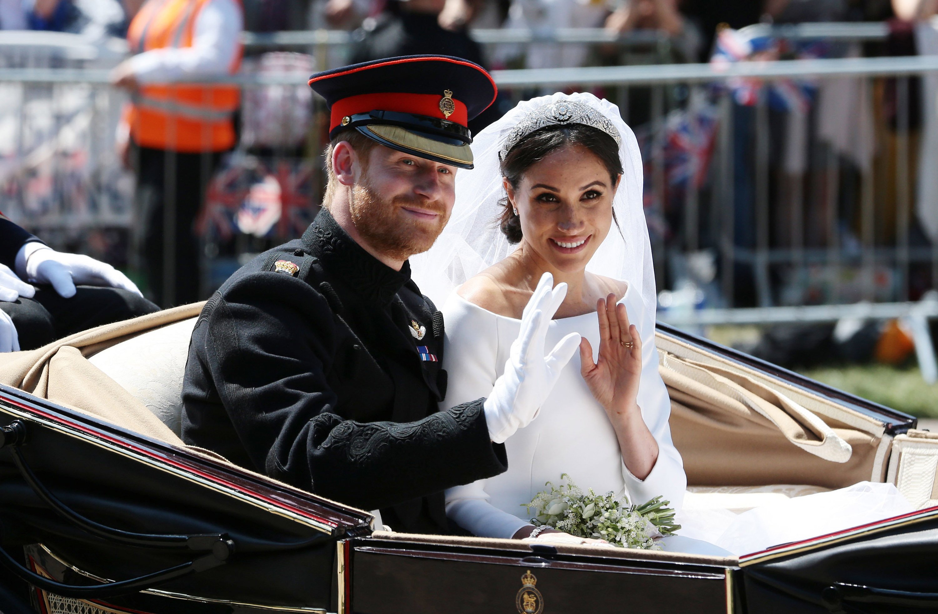 Prince Harry, Duke of Sussex and Meghan, Duchess of Sussex wave from the Ascot Landau Carriage during their carriage procession on Castle Hill outside Windsor Castle in Windsor, on May 19, 2018 after their wedding ceremony. | Source: Getty Images