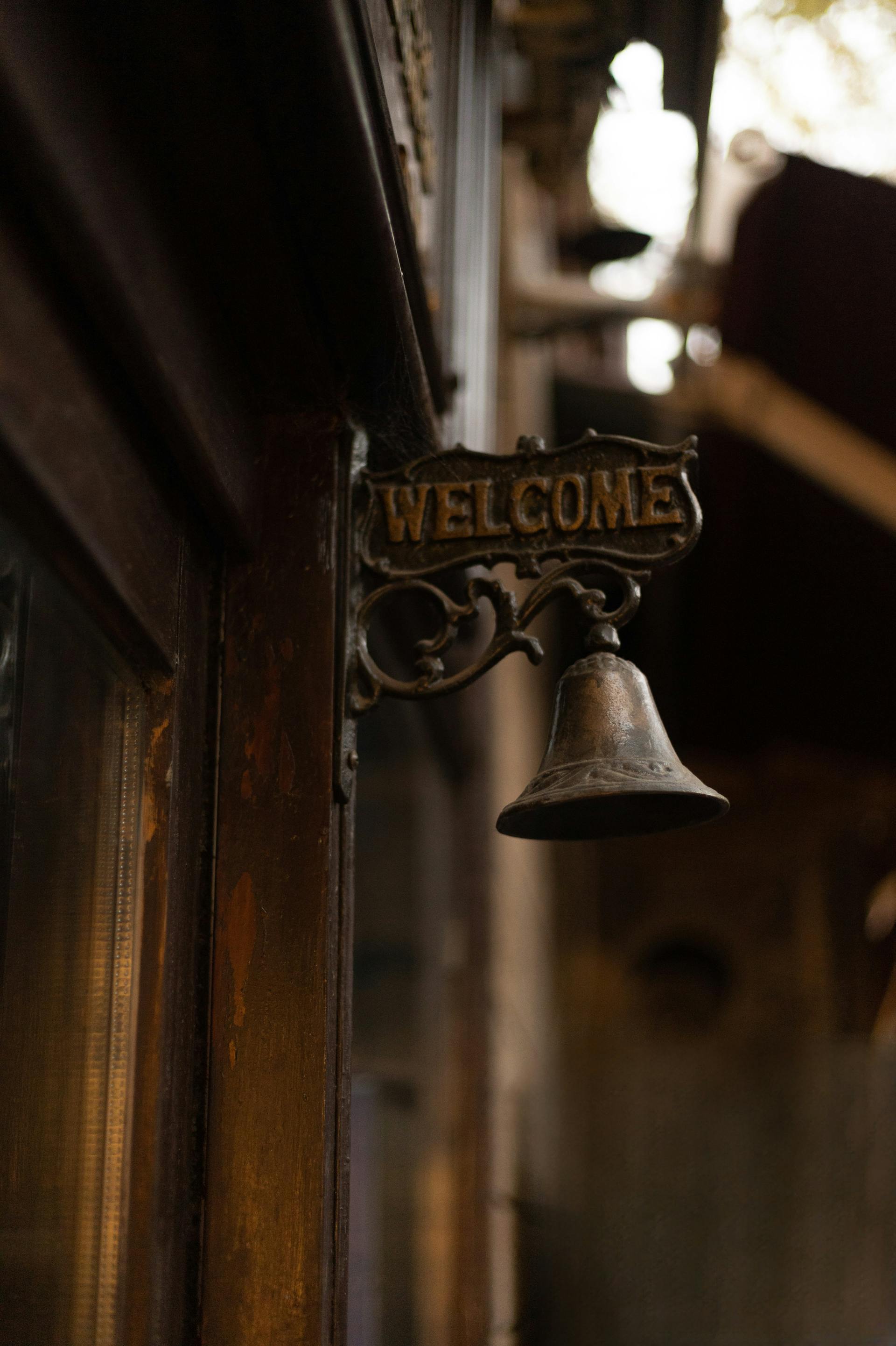 A brass bell atop a wooden door | Source: Pexels