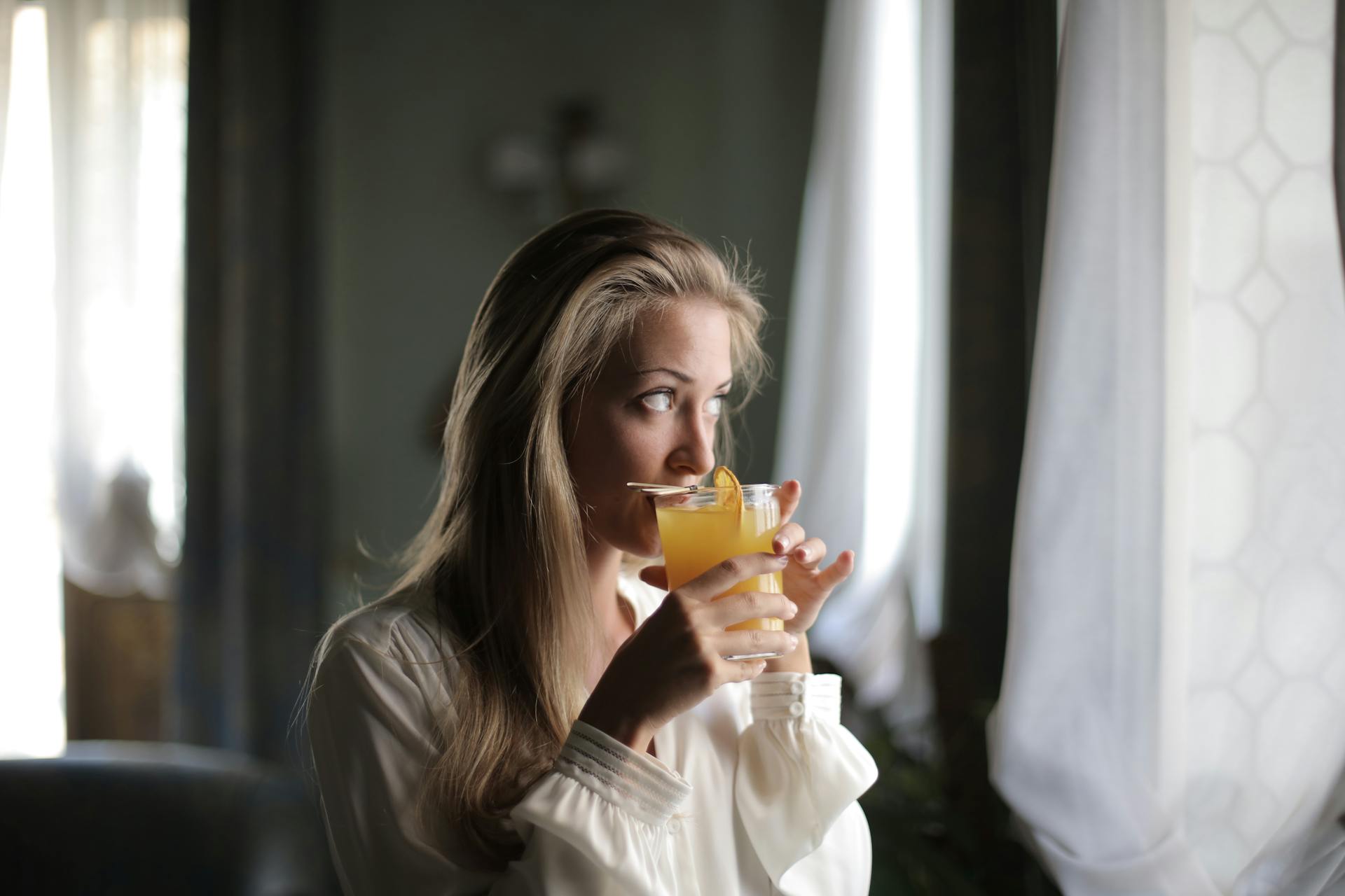 A woman drinking orange juice | Source: Pexels